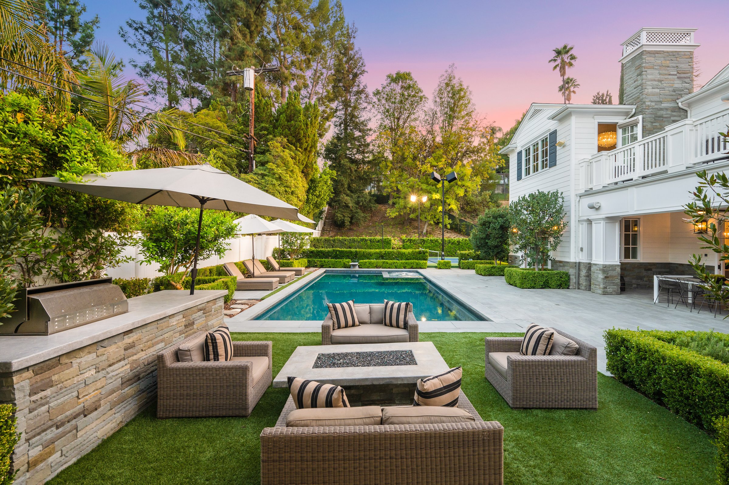 A poolside patio with outdoor dining table in a new construction home in Encino, California