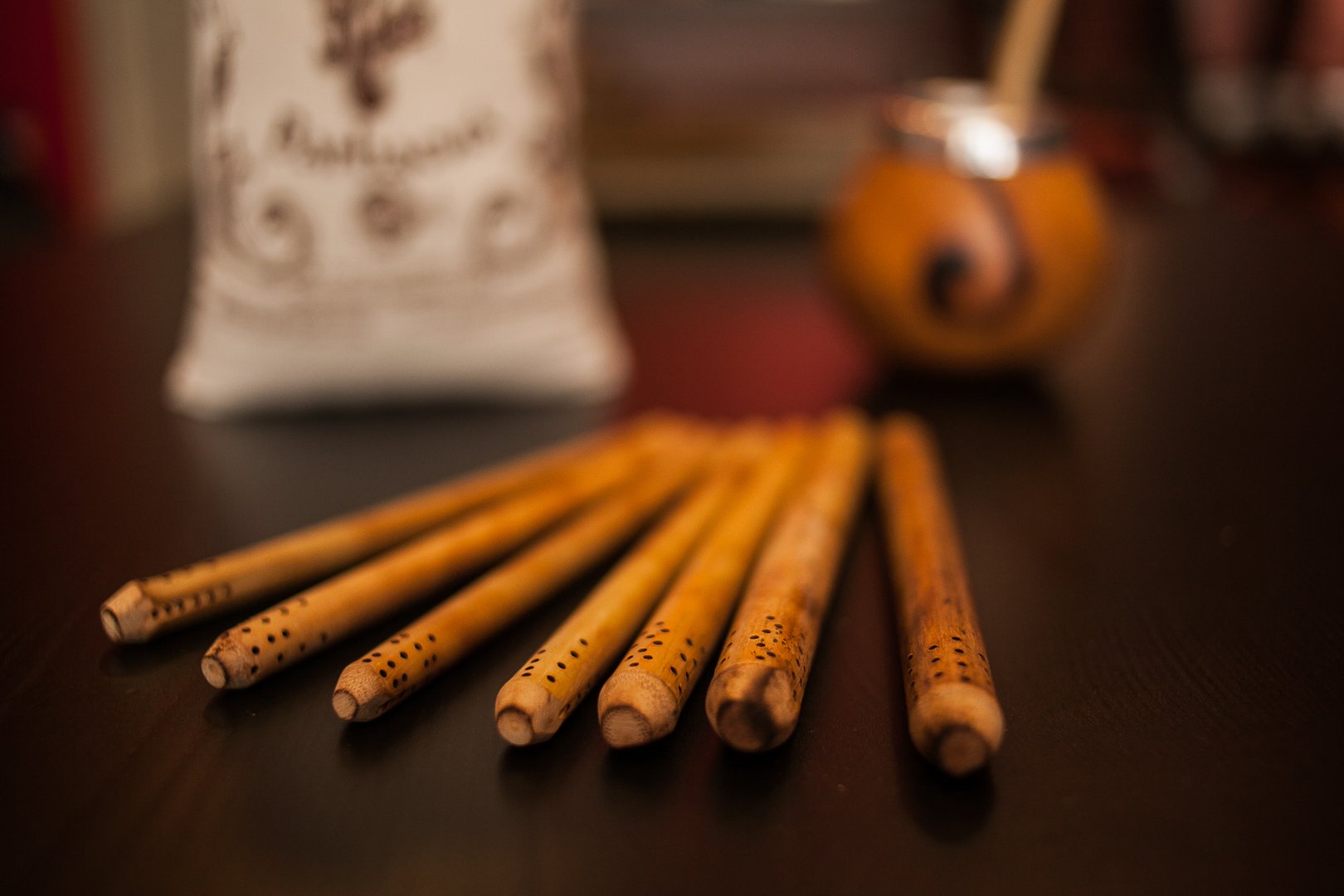 A collection of hardwood sticks are arranged neatly on a table, providing a rustic and artistic touch. They can be used for cuisine, as musical instruments, or as props for still life photography