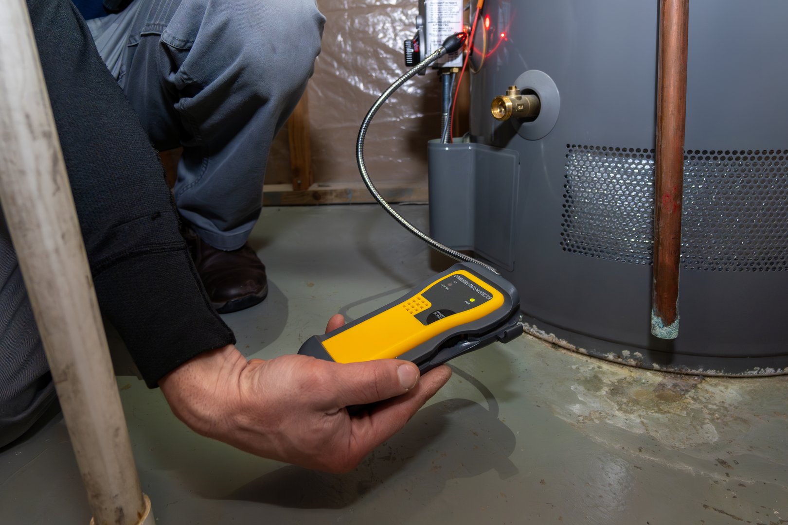 Home Inspector searching and using UEFI carbon monoxide detector to test gas furnace.