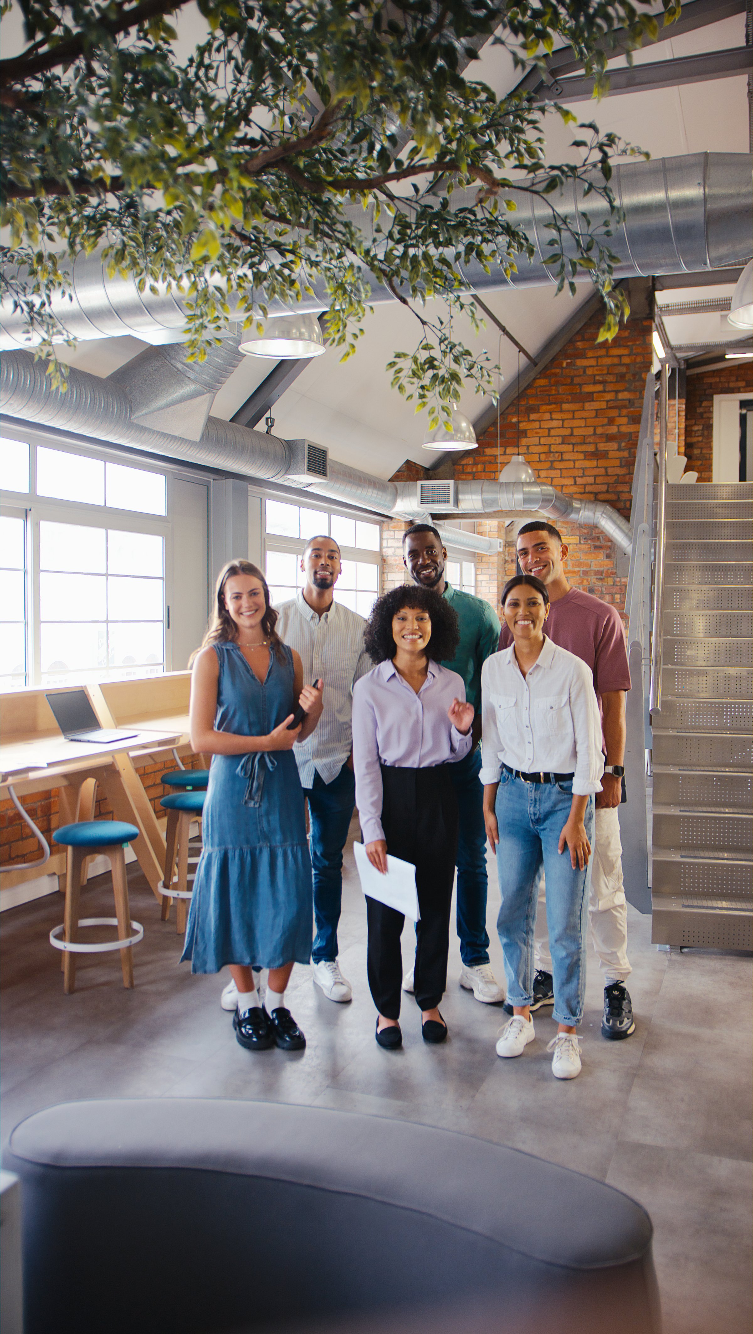 Portrait Of Multi-Cultural Business Team Standing In Modern Open Plan Office Together