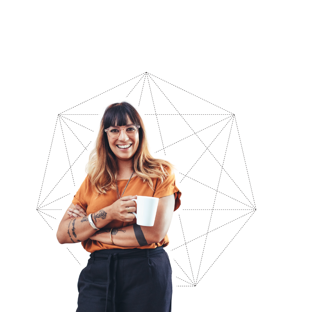Smiling woman with glasses holding a mug, standing in front of a geometric background, wearing an orange top and dark pants.