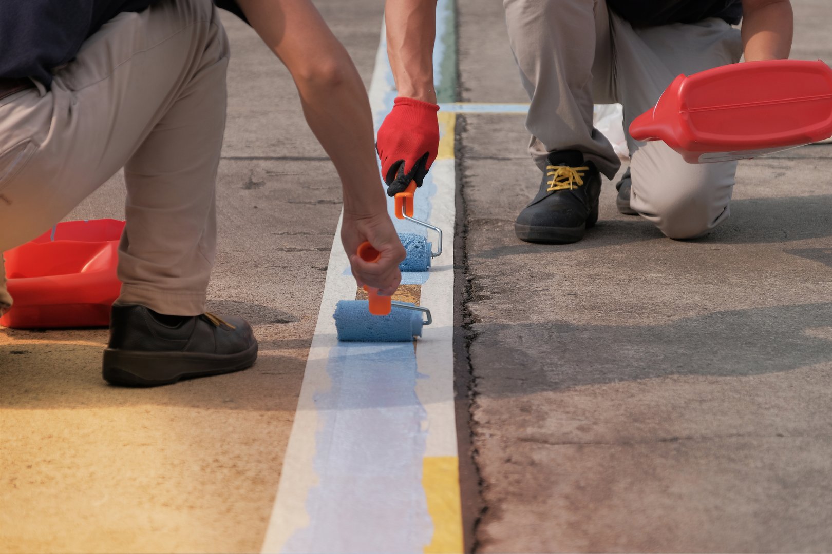 Workers repainting parking lot lines with professional equipment