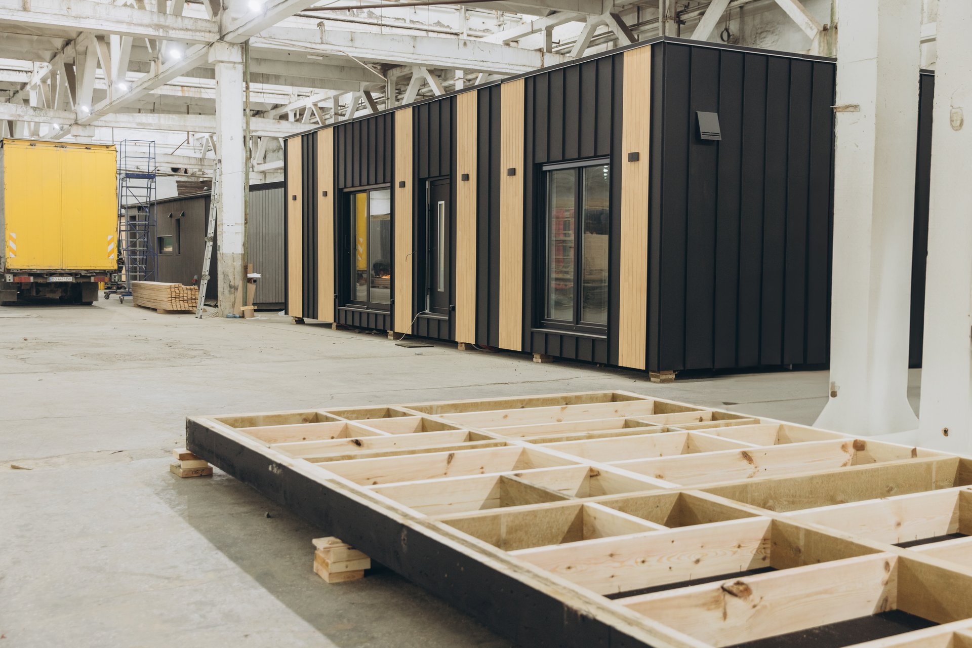 Modular house being built inside a factory, showing the wooden frame and the almost complete module