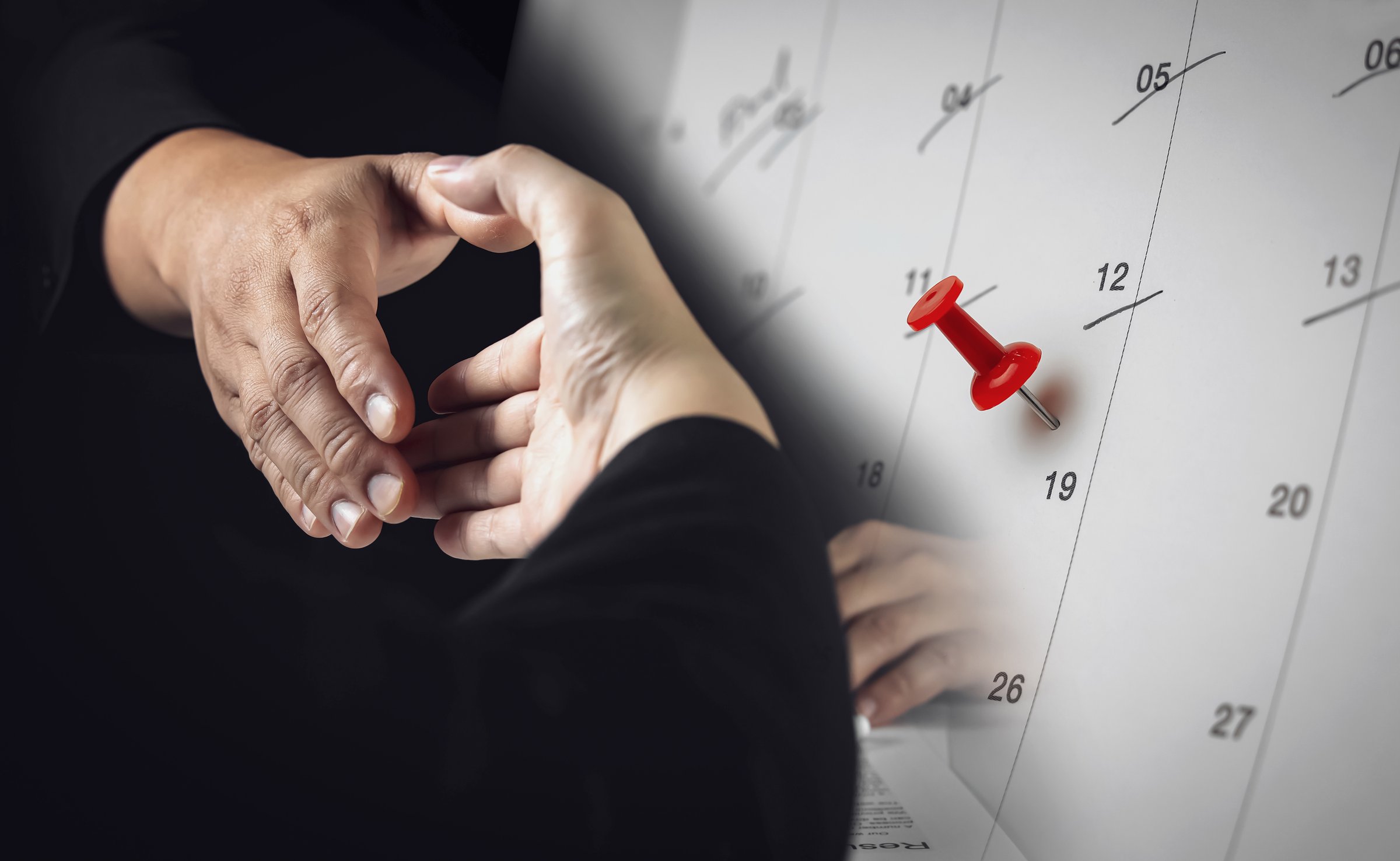 Handshake for cooperation with red pin on calendar. Concept of making deals and important business