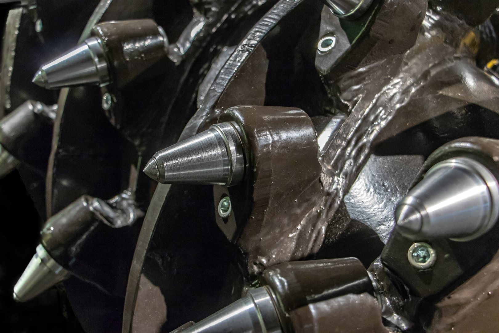 The detail of head of drilling machine for mine. Spines of coal mine excavator underground, close up.