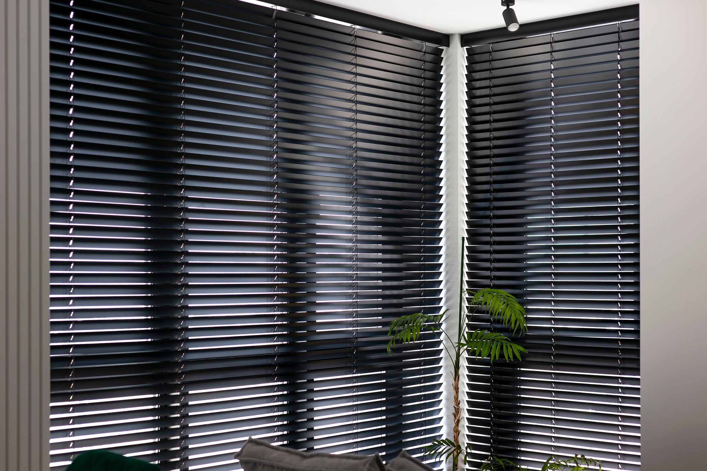 Automatic venetian blinds. Black color motorized wood blinds. Smart wooden shades on the window in the interior. Closed lamella shutters.