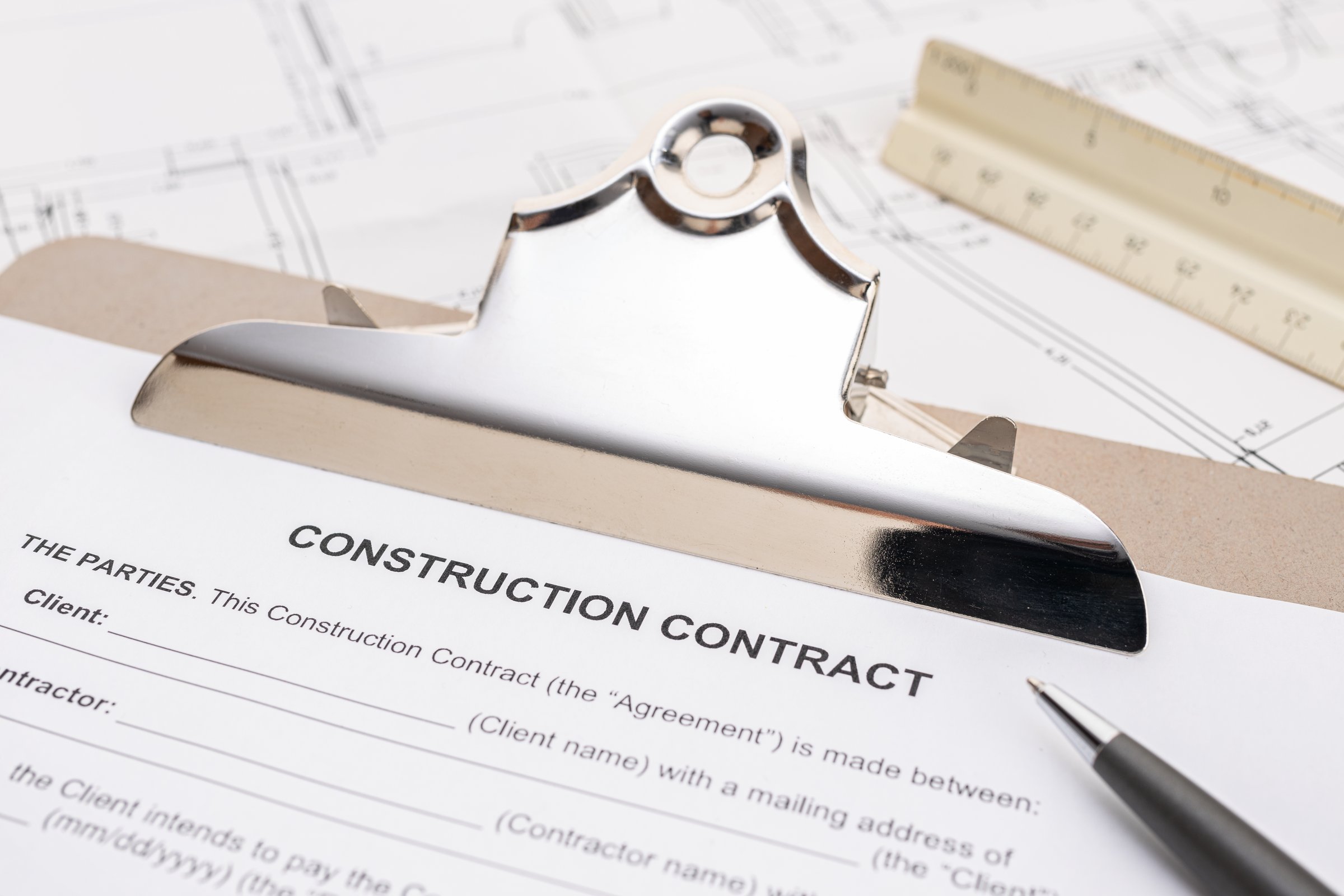 Construction contract document and pen on table. Real estate and planning of building a house or project home