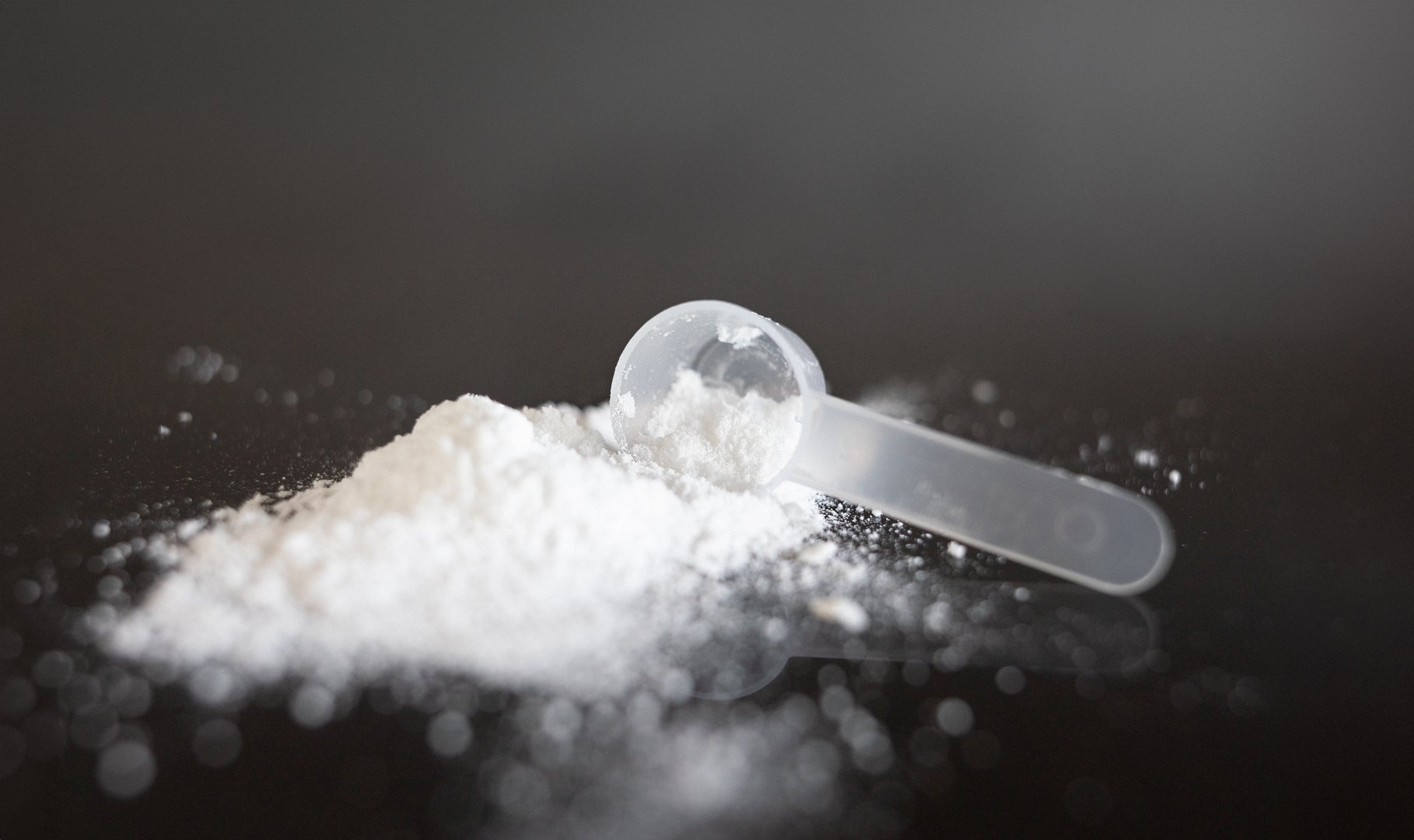 Close-up of creatine powder with spoon.