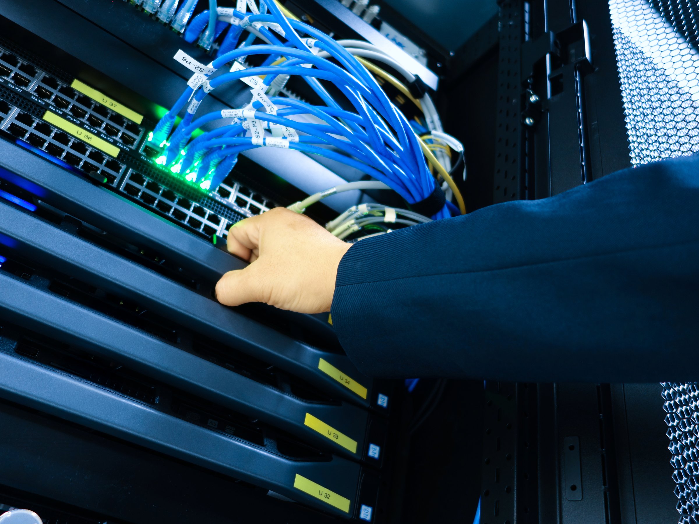 A technician performs server maintenance in a data center, showcasing the importance of connectivity and efficiency in modern technology environments.