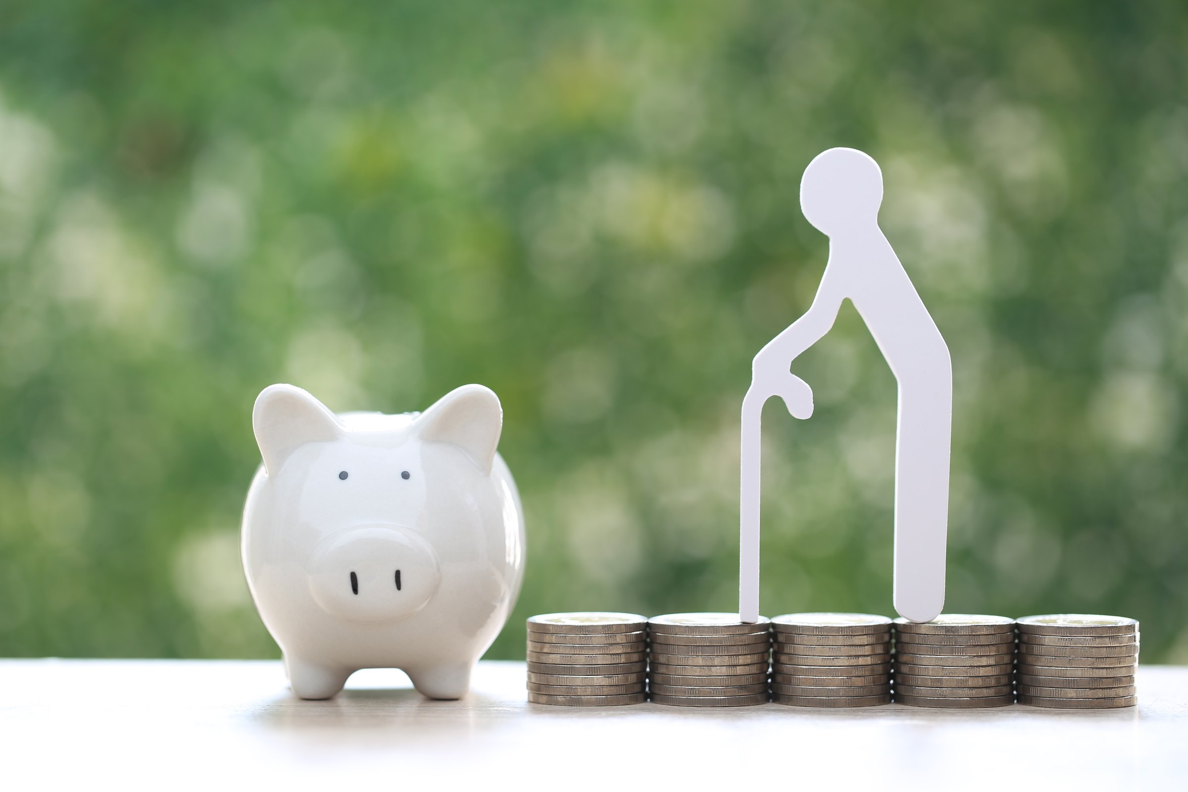 Mutual fund,Senior man on stack of coins money and piggy bank on natural green background, Save money for prepare in future and pension retirement concept