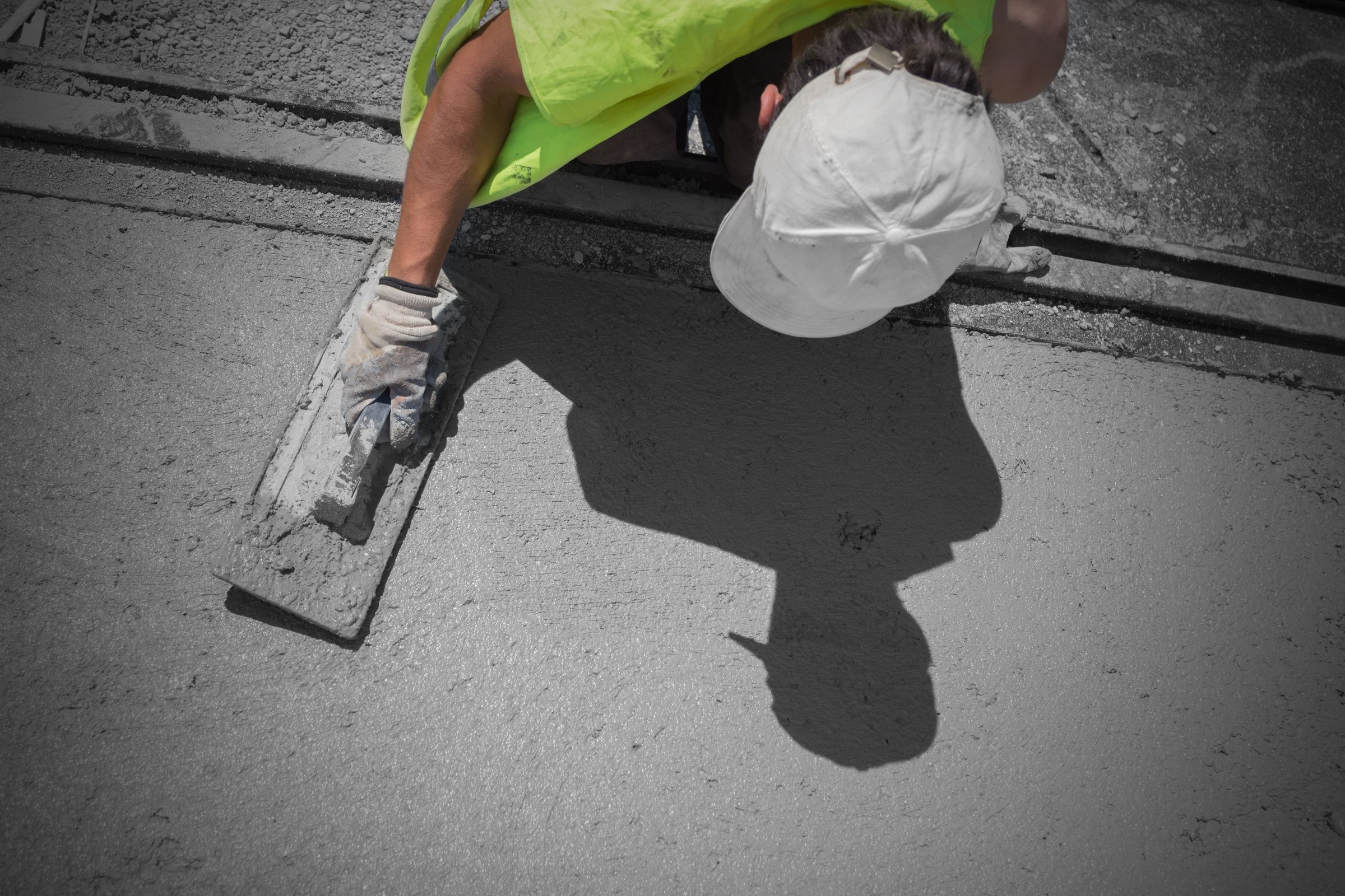 Construction workers leveling concrete pavement.
