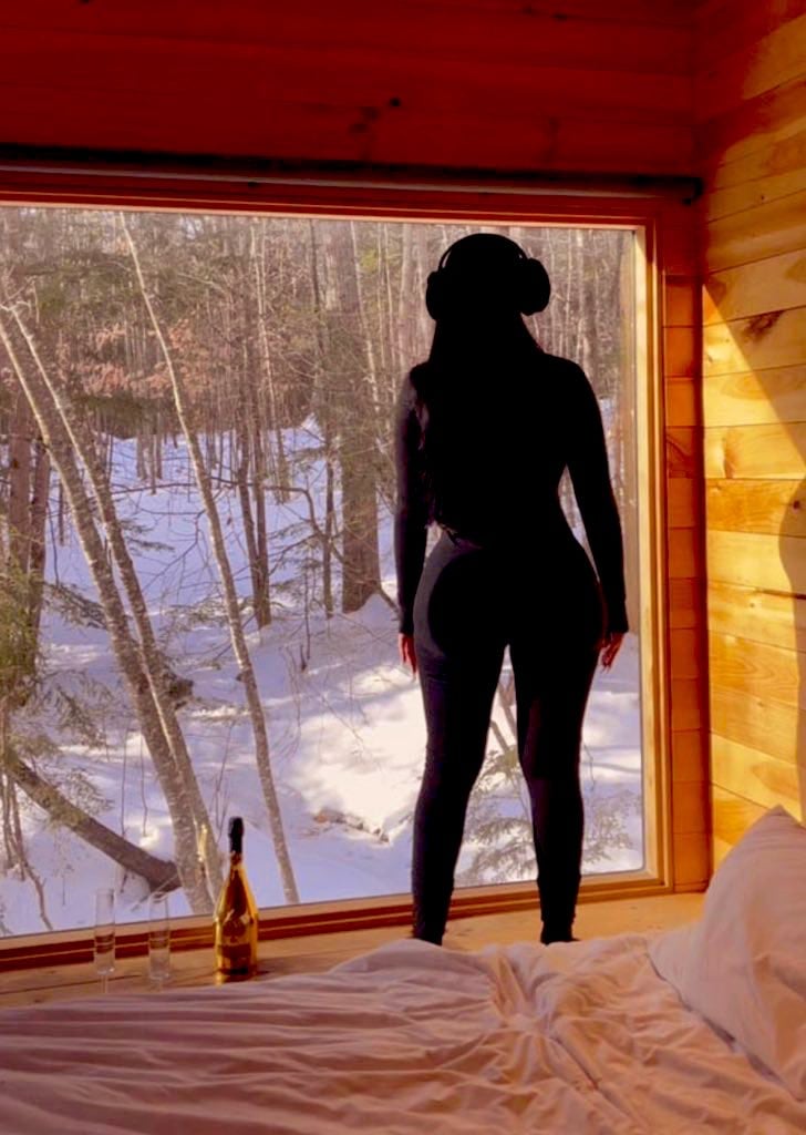 Woman holding Christmas gift boxes with makeup brushes and cosmetics at home, above view