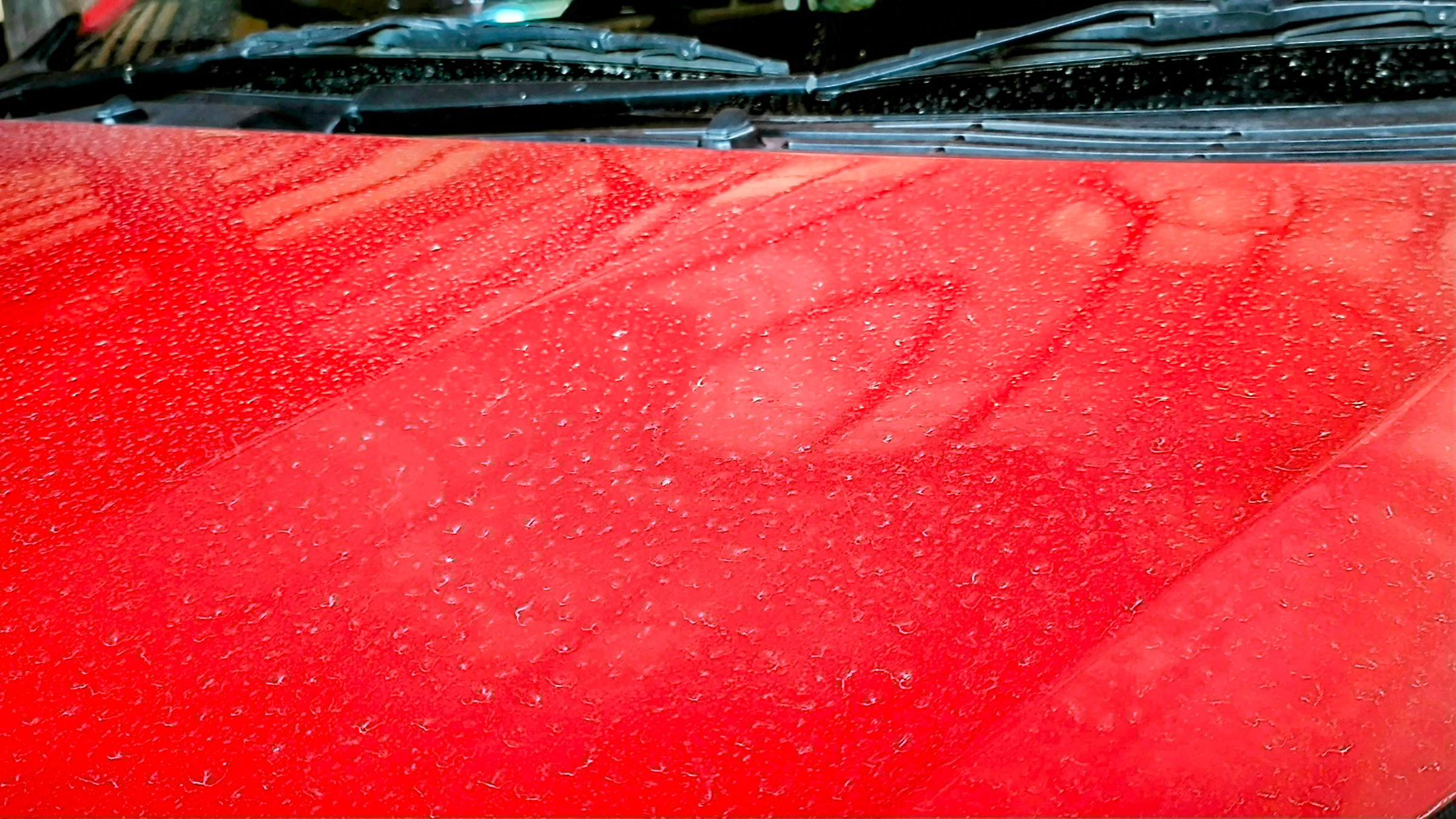 Photo of red car full of dust. Dusty car