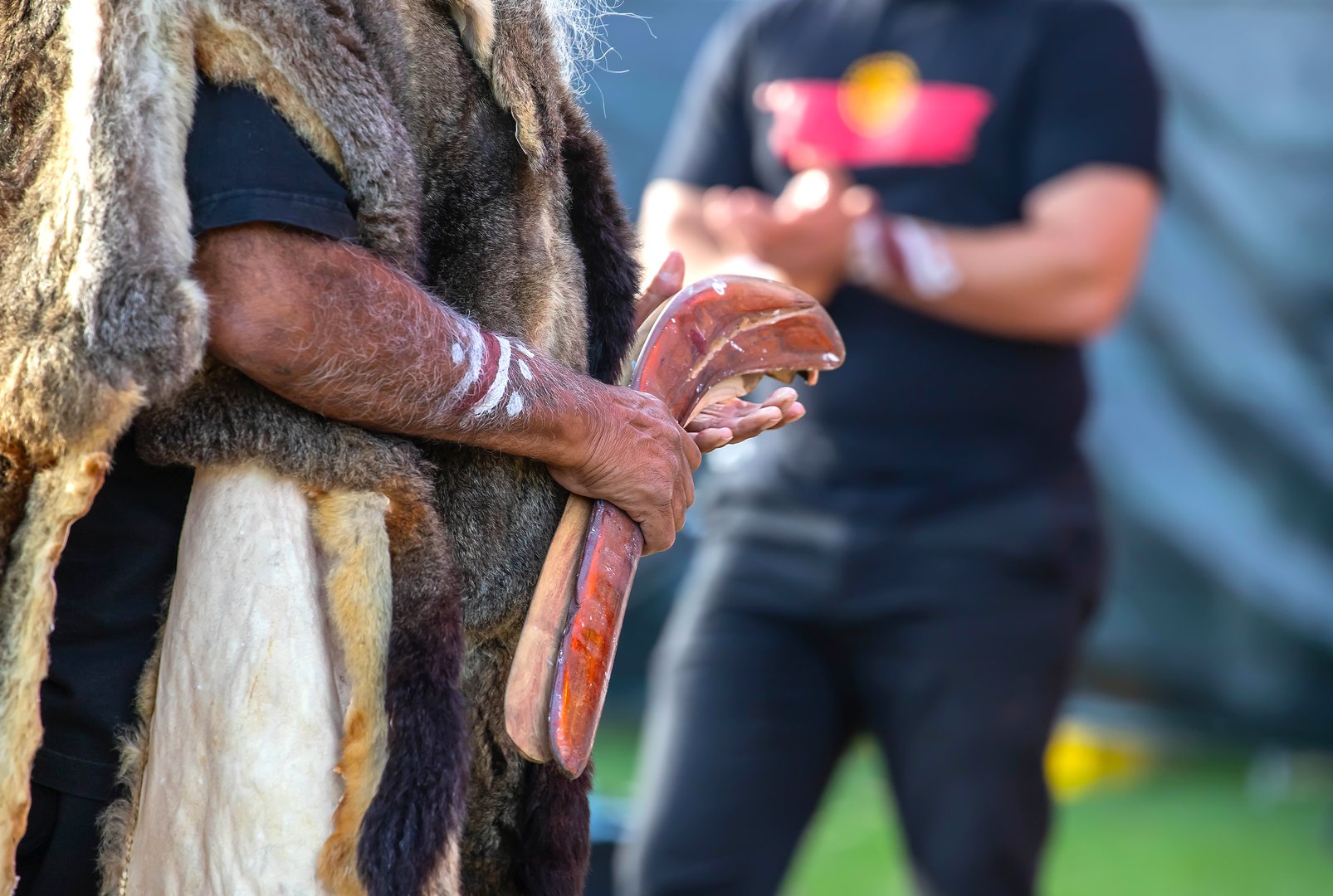 Australian aboriginal ceremony, human hand holds ritual clapsticks for the welcome rite at an indigenous reconciliation community event in Australia