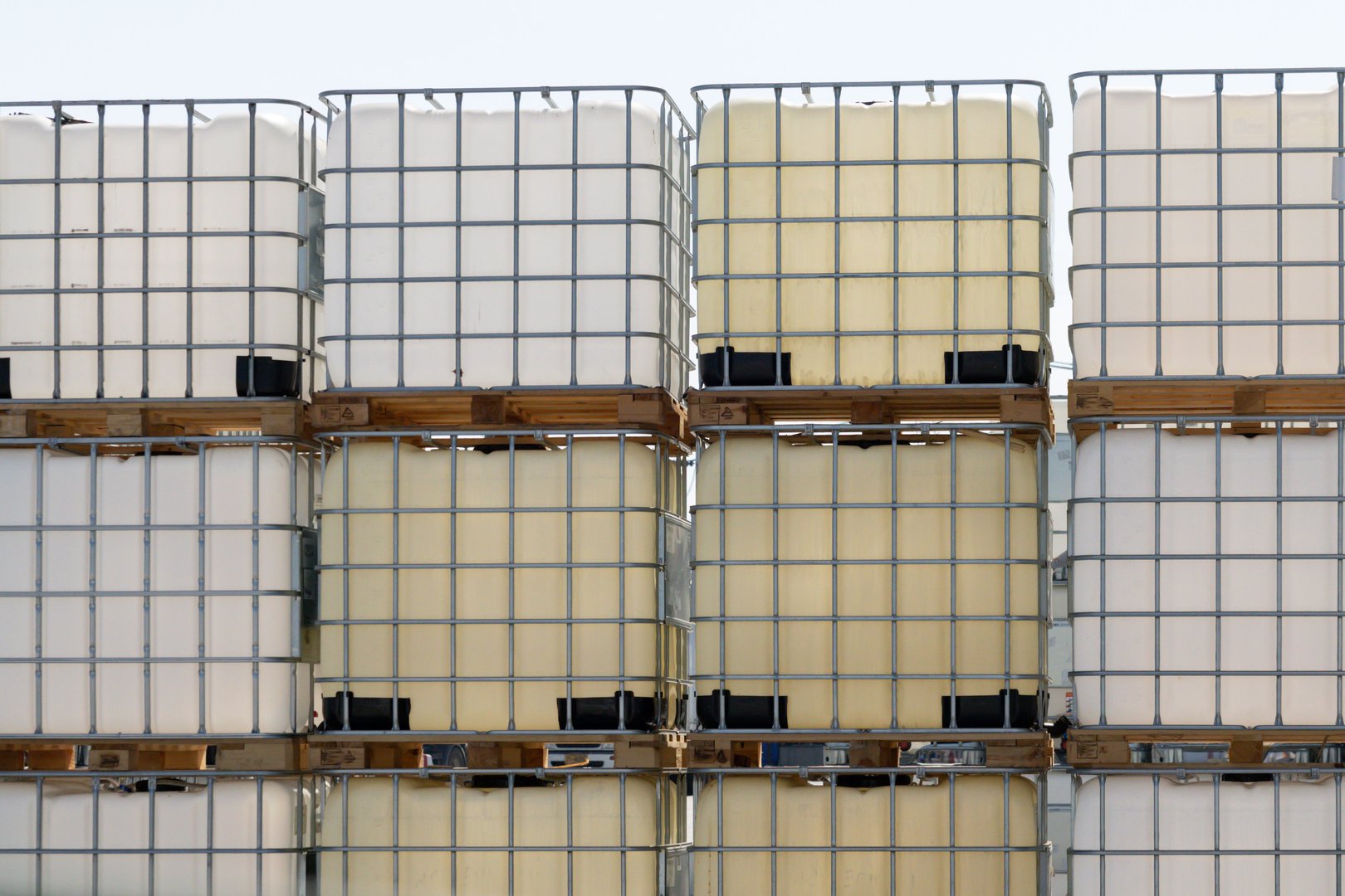 A stack of white and yellow plastic containers. The containers are stacked on top of each other. The containers are made of plastic and are of different sizes