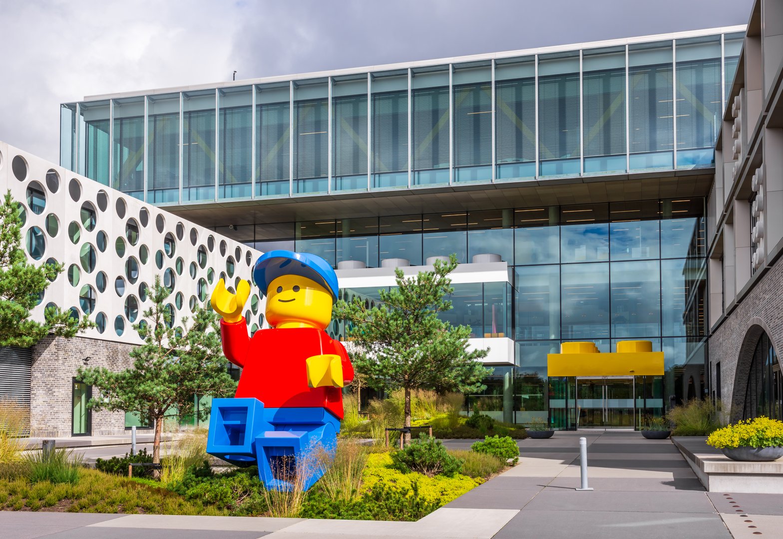 Billund, Denmark - July 14, 2024: A giant Lego minifigure is set in front of the entrance of the Lego Campus, headquarters of the Lego Group, a Danish construction toy production company.