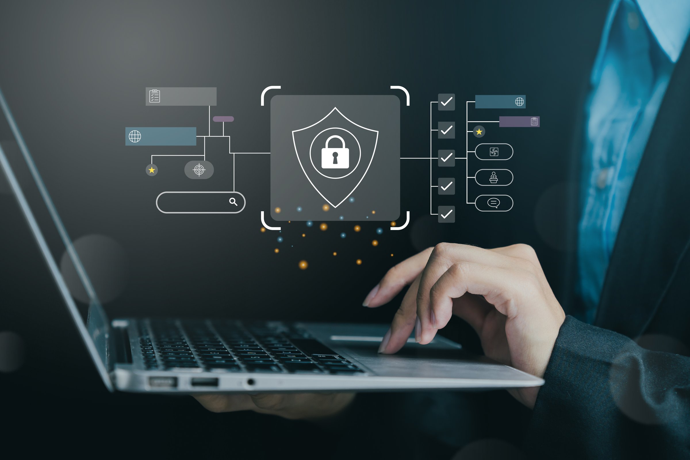 Close-up of a person working on a laptop with digital security interface on screen, emphasizing cybersecurity and data protection.
