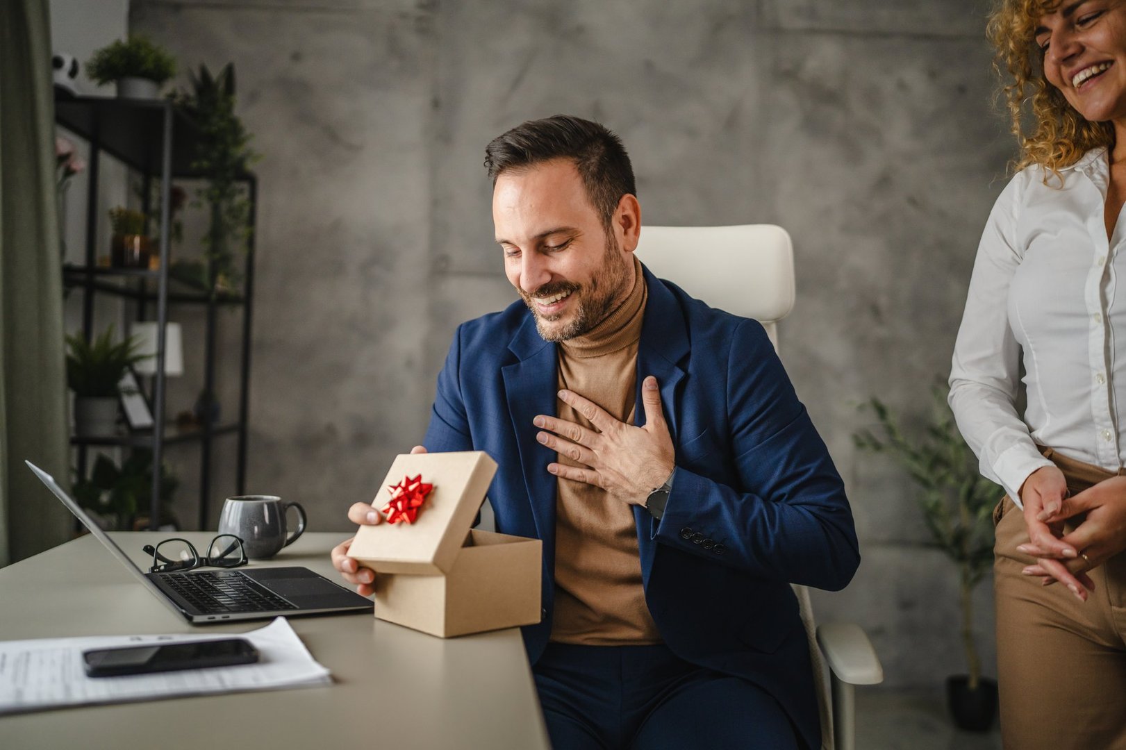 Female colleague surprise with gift her male colleague in the office