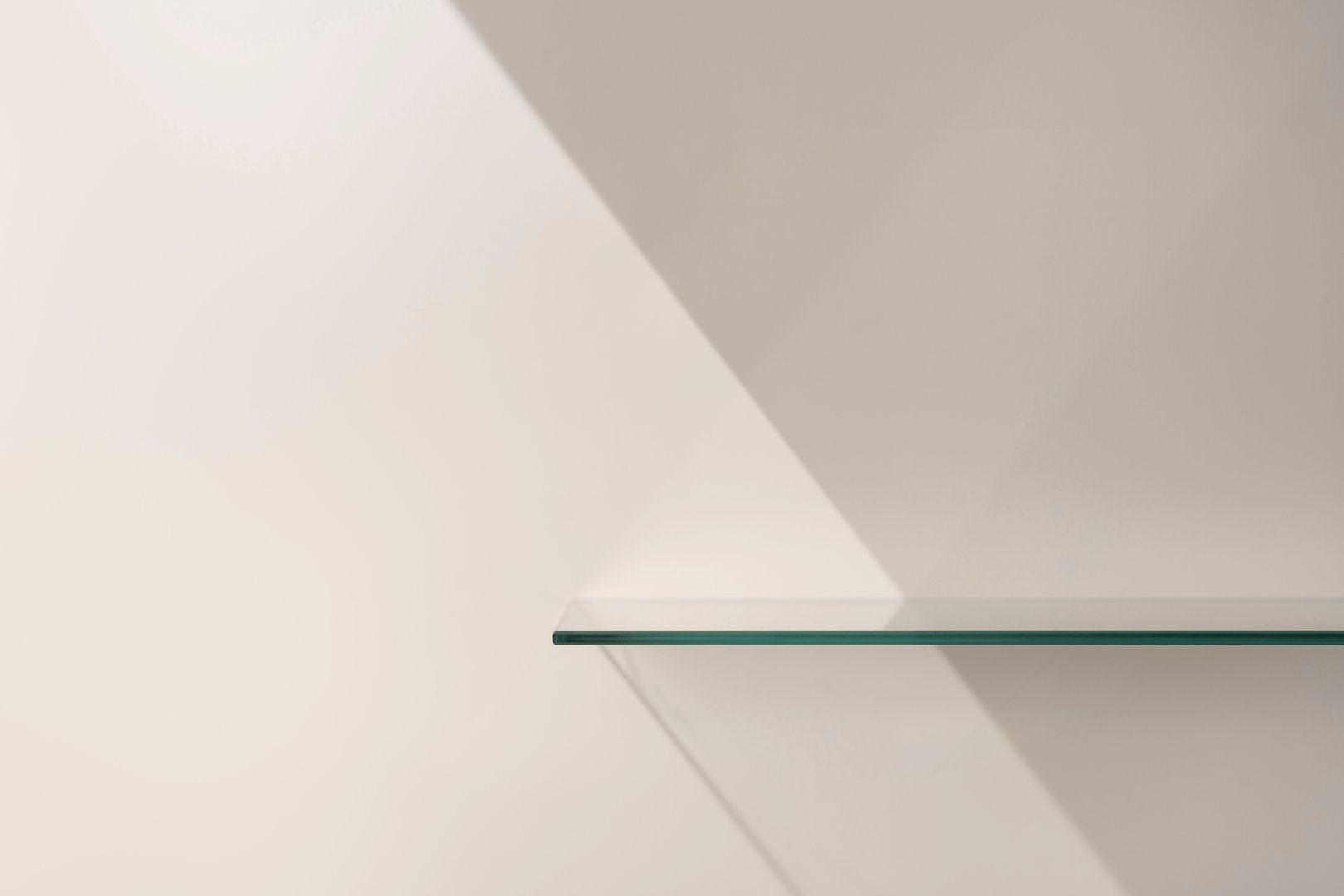 Elegant minimalist mockup glass shelf against neutral beige wall with soft natural light.