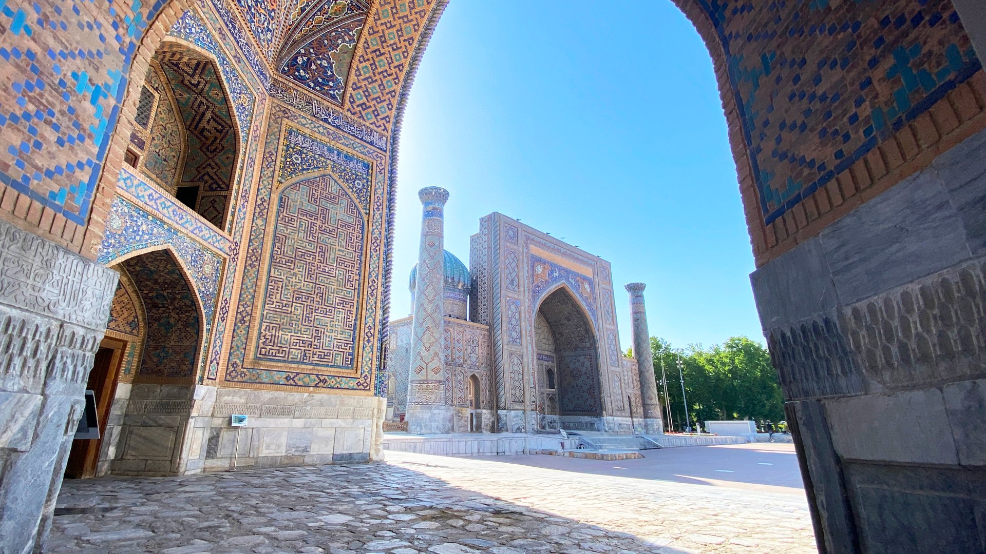 View of Registan Square and Sherdor Madrasah from Tillya-Kori Madrasah. The business card of Samarkand. Tourism and adventures in Uzbekistan.