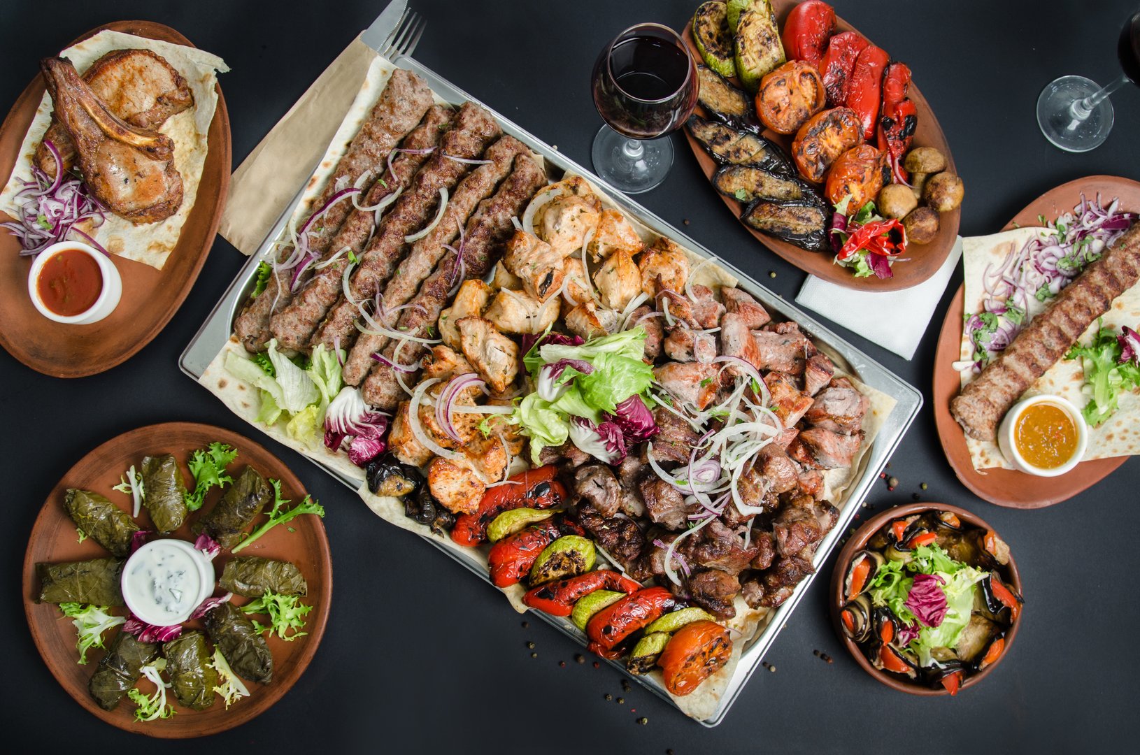 Many types Georgian shish kebab, Mtsvadi with sauce and onion. Georgian cuisine. A large laid table of different dishes for the whole family on a day off.