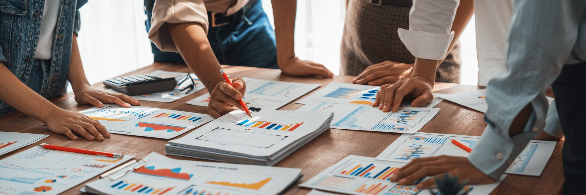 Analyst team utilizing BI Fintech to analyze and pointing at financial dashboard paper office. Businesspeople examining report paper on table for business insight. Panorama shot. Scrutinize