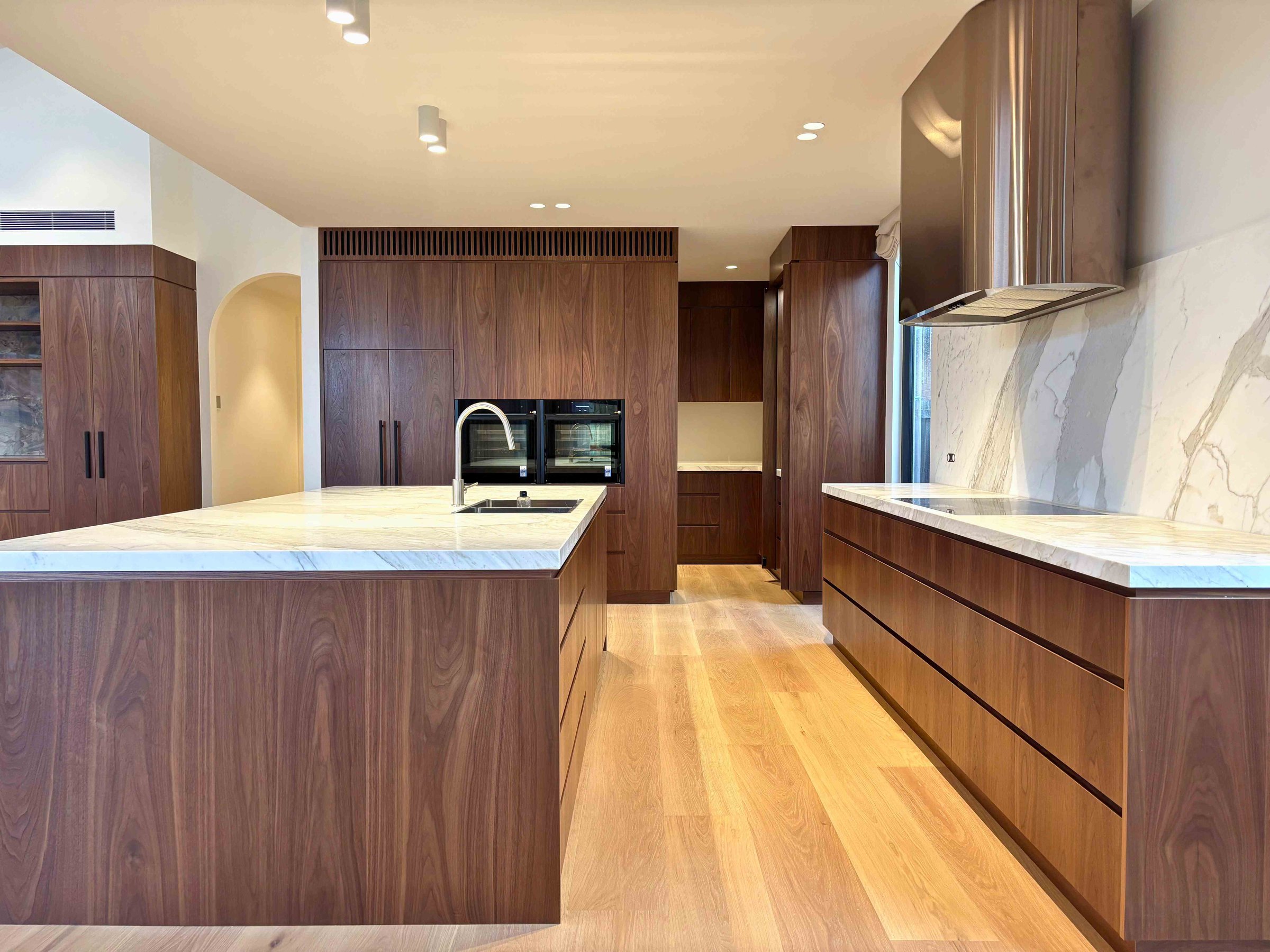 Featured minimalist kitchen project by Individual Design featuring American Oak veneer and natural stone benchtops
