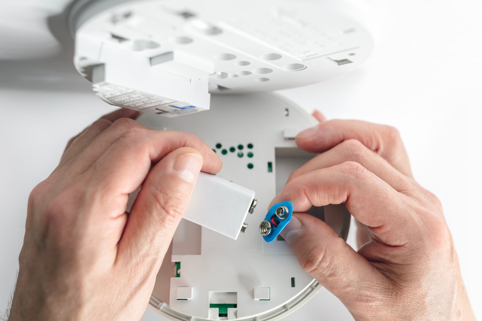 Home smoke and fire alarm detector man installing, maintenance, checking, testing or replace battery