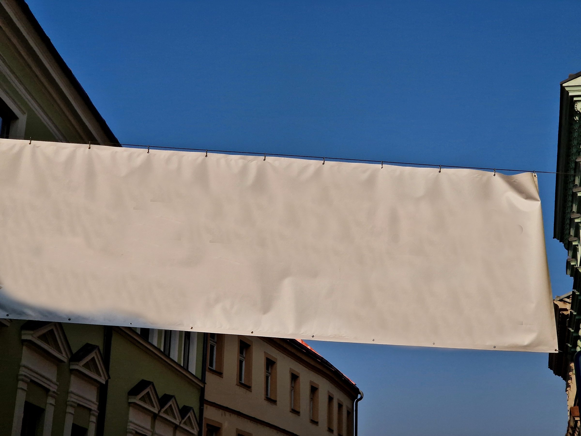 white advertising tarpaulin installed by a cable into the metal galvanized frame and shackled holes