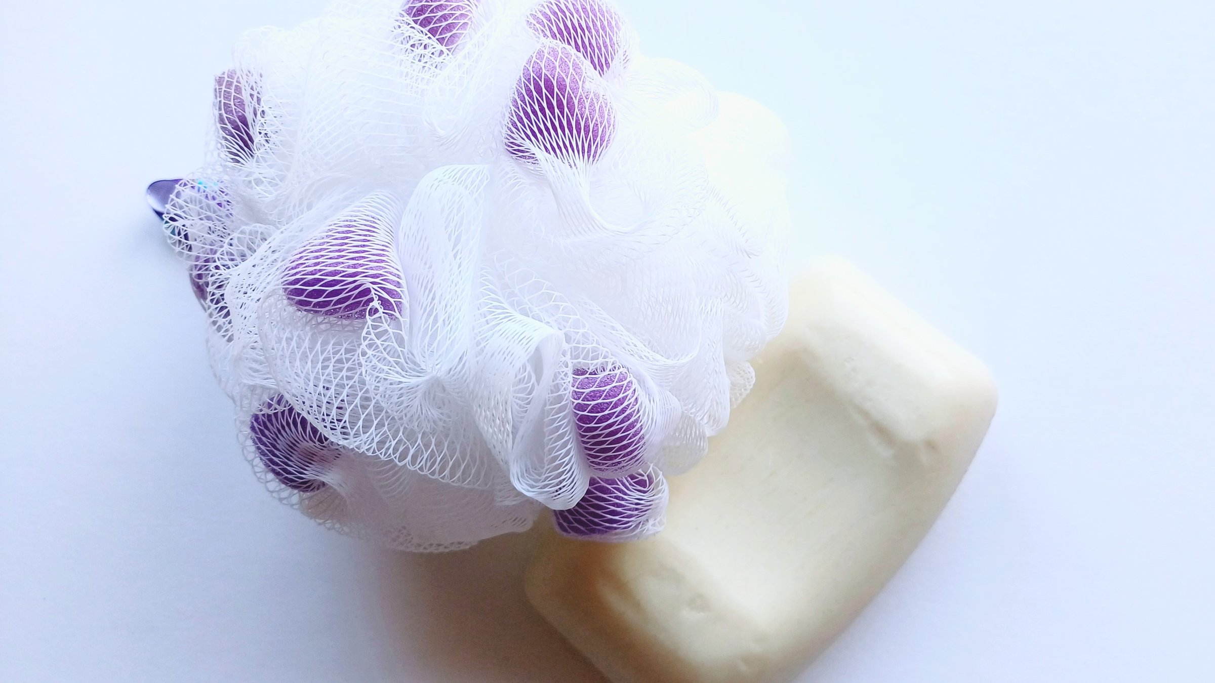 Bath loofah and white soap on a white background.