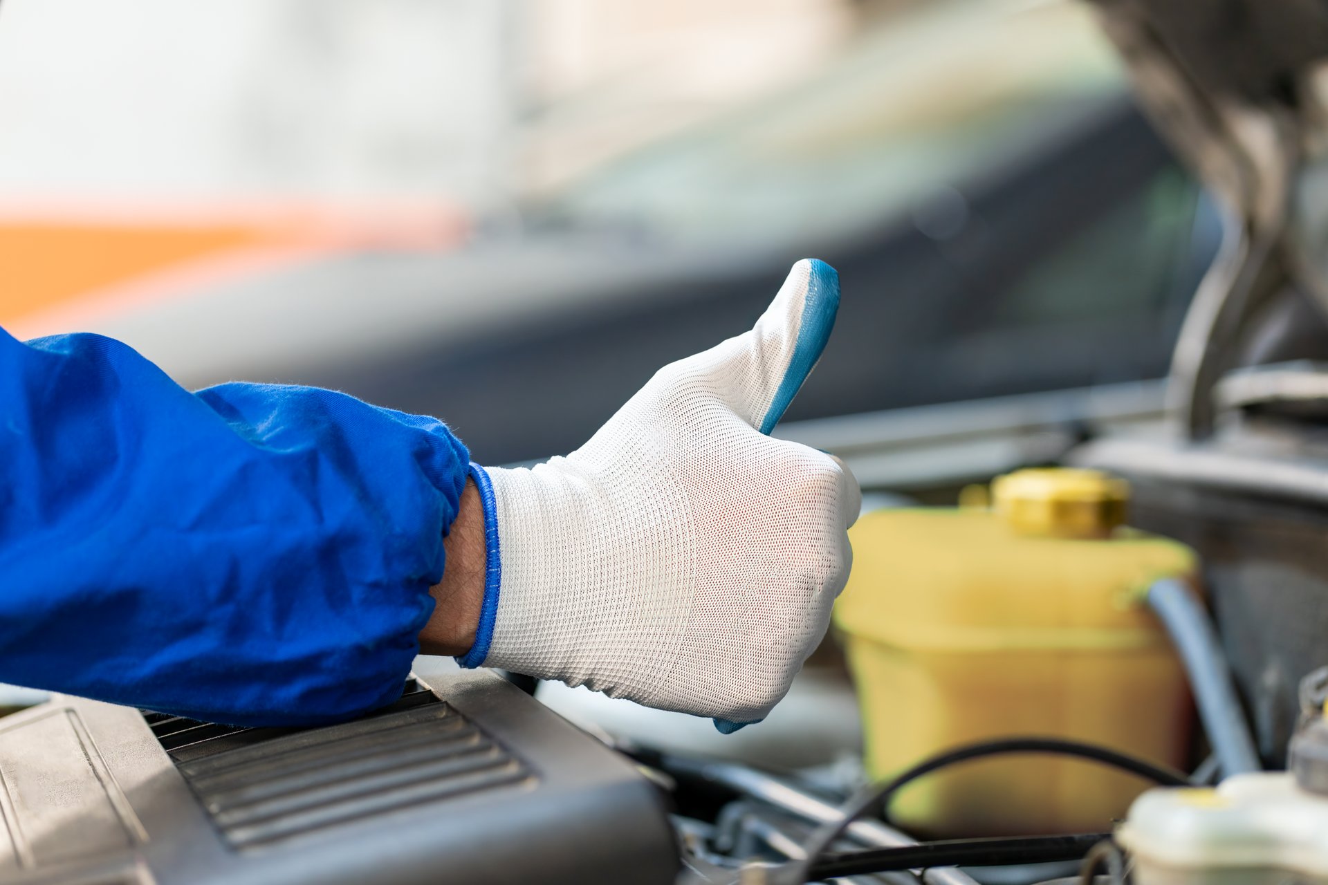 Cropped image of mechanic working in auto service showing Ok sign