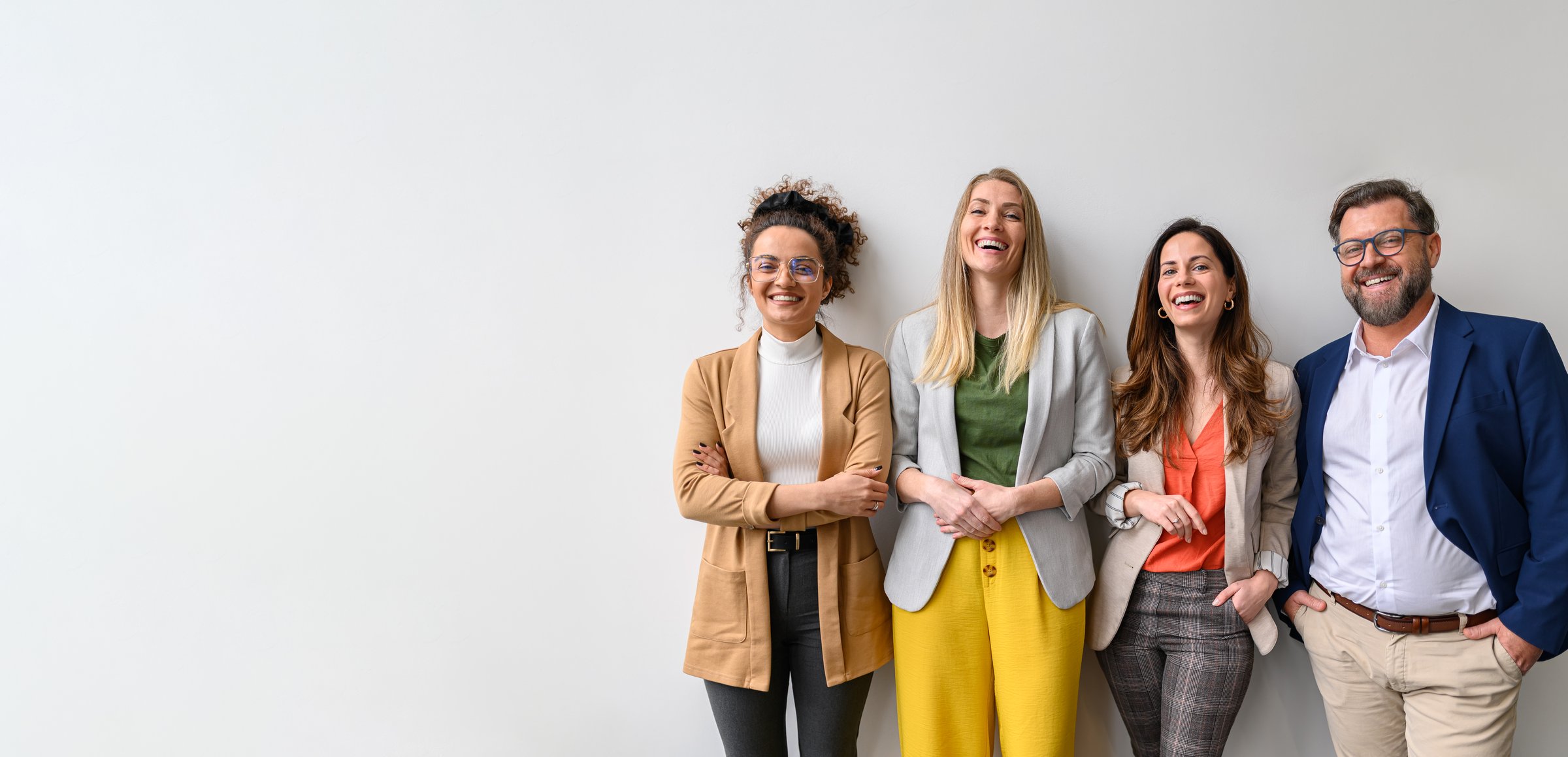 Portrait of smiling male and female business professionals standing and posing together against white background