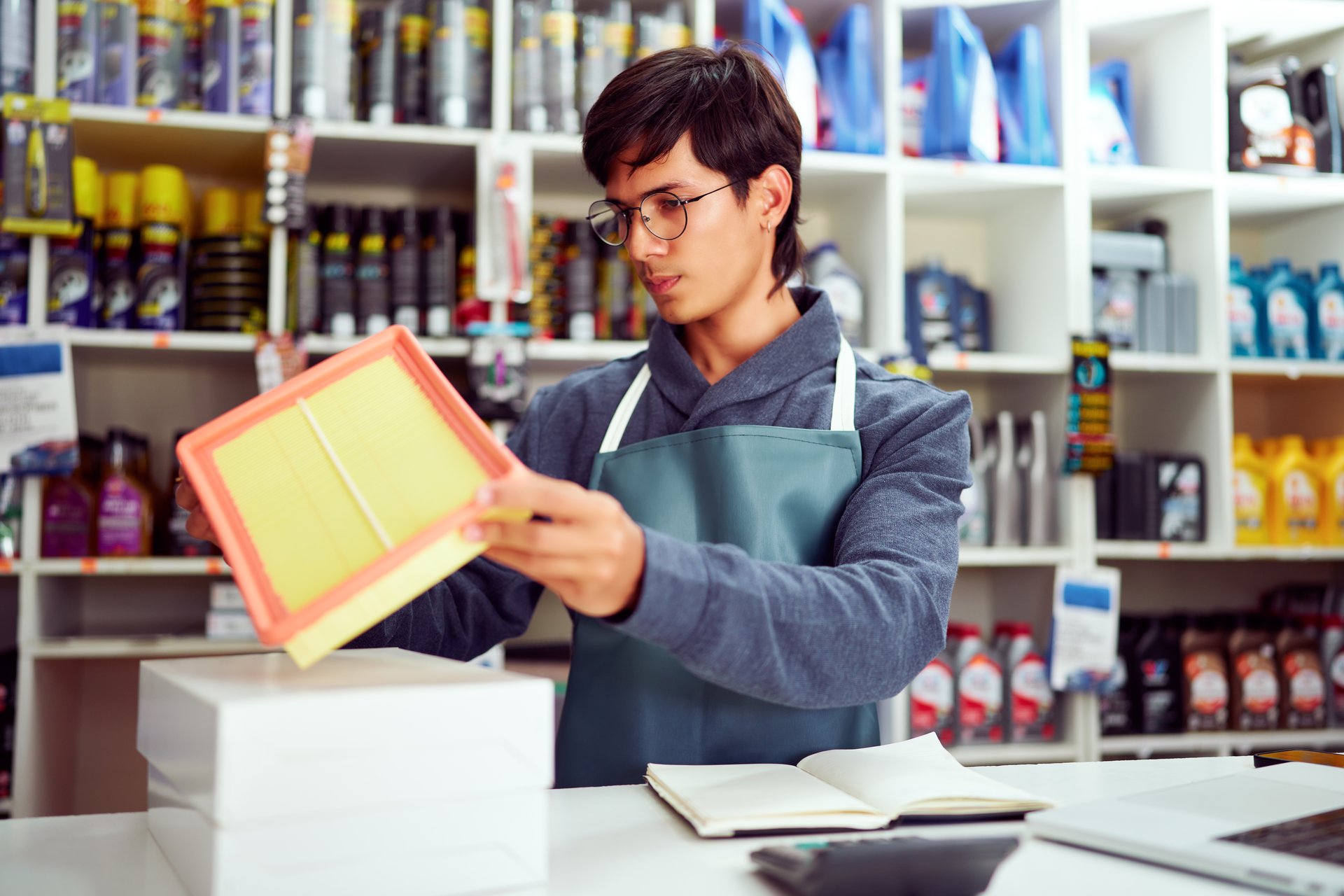Auto mechanic examining new air filter in spare parts shop