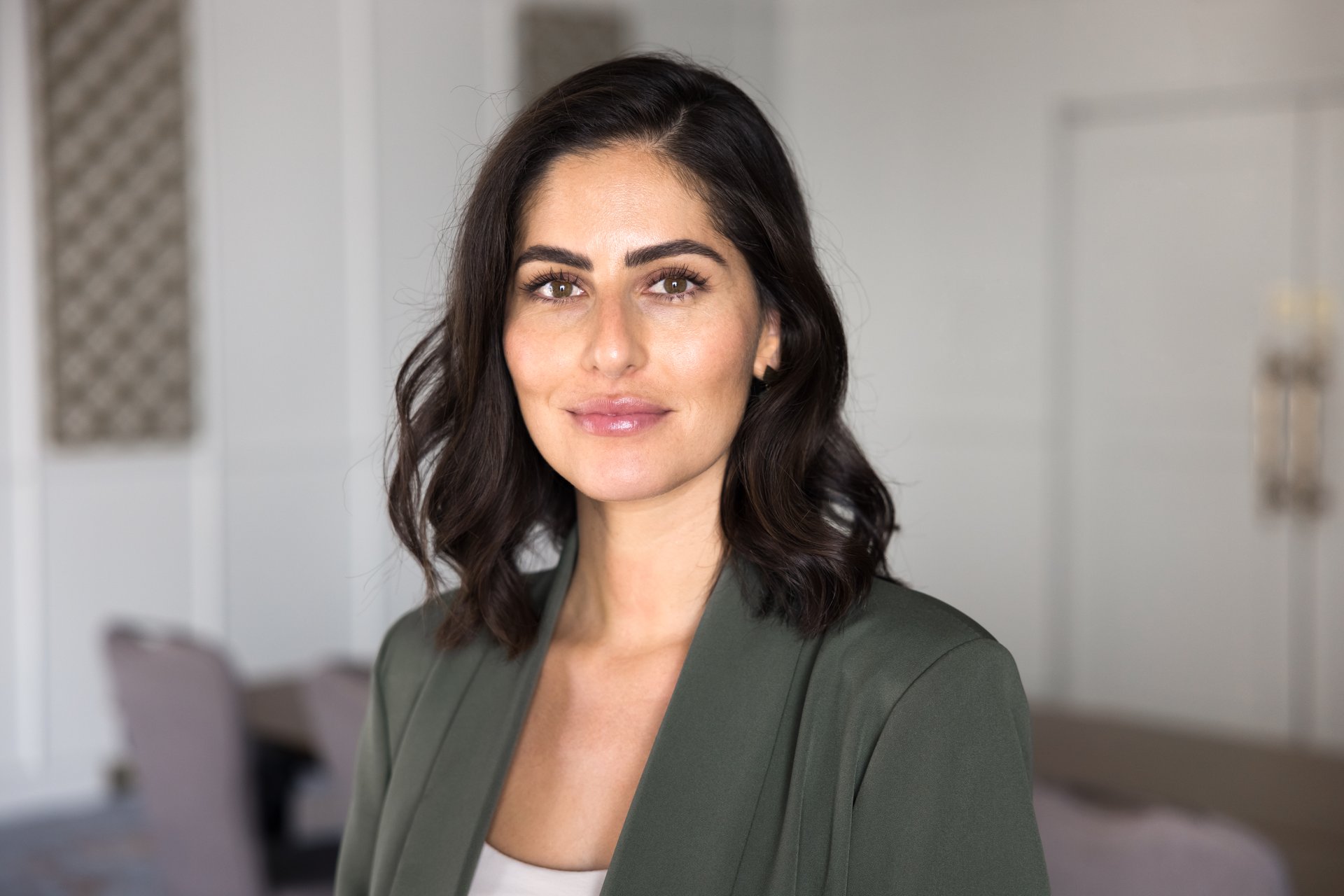 Positive beautiful Hispanic business professional woman posing in office, looking at camera. Successful young Latin female company leader, owner professional head shot portrait