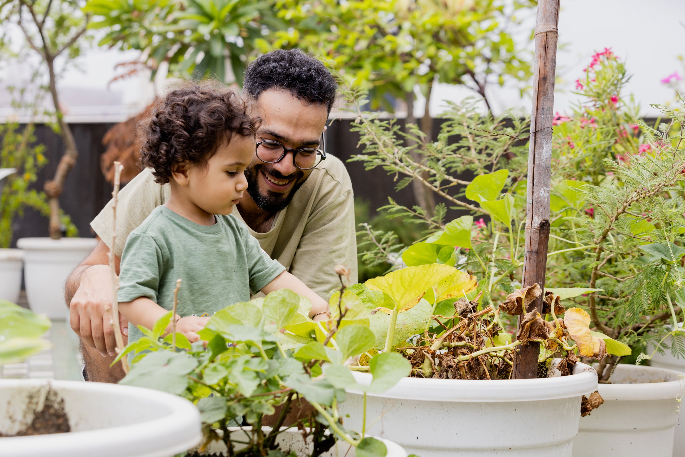 Father and Child Enjoying Gardening Together in a Lush Garden