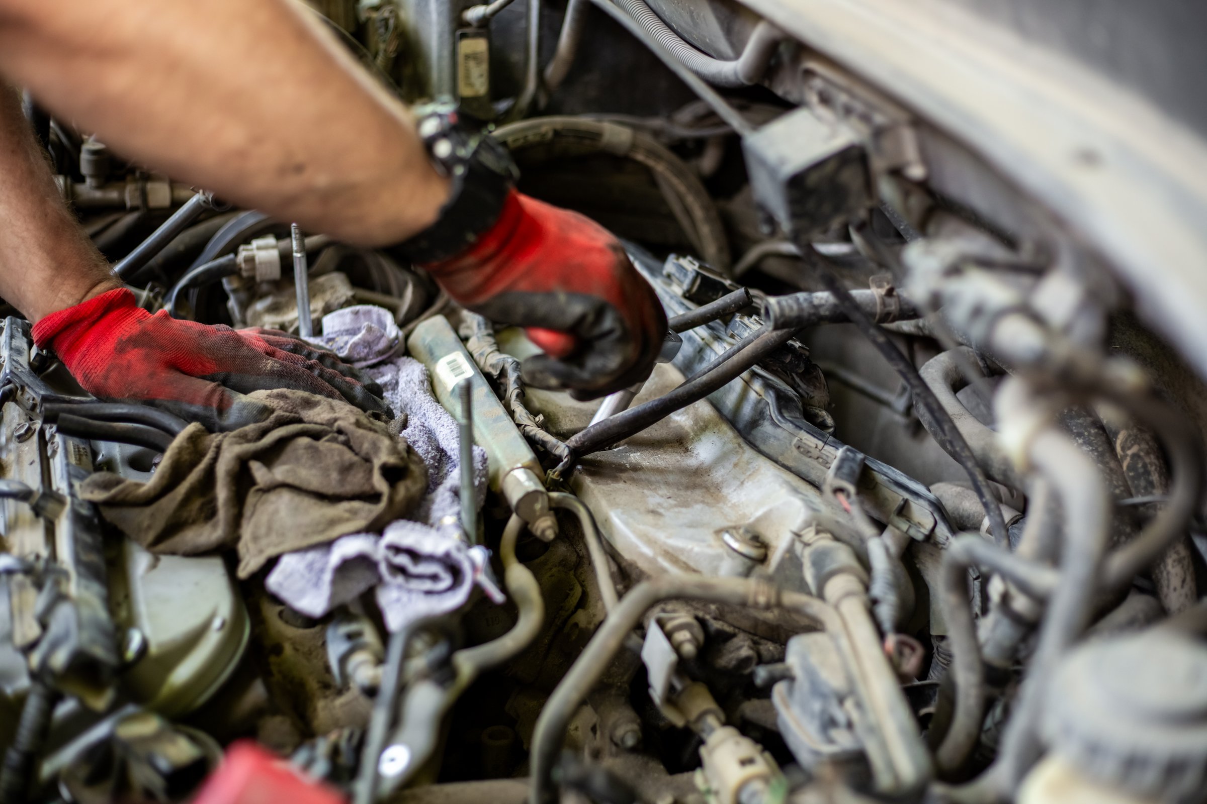 Car repair. Mechanic removes valve covers of the timing mechanism.