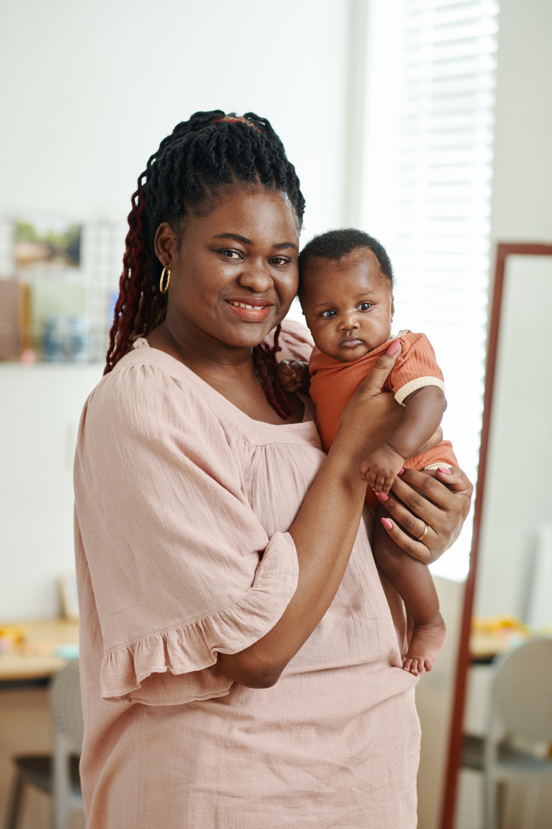 Portrait of happy smiling Black woman holding new little baby girl