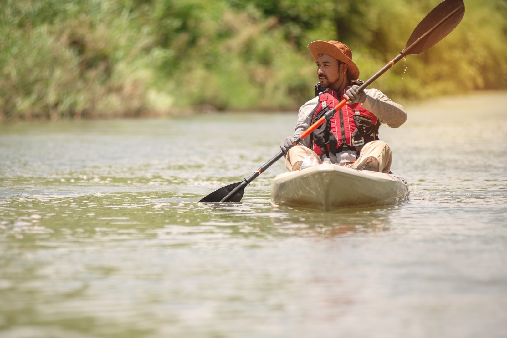 Adventure tourists kayaking and admiring the nature on both sides of the river, adventure tourism concept.