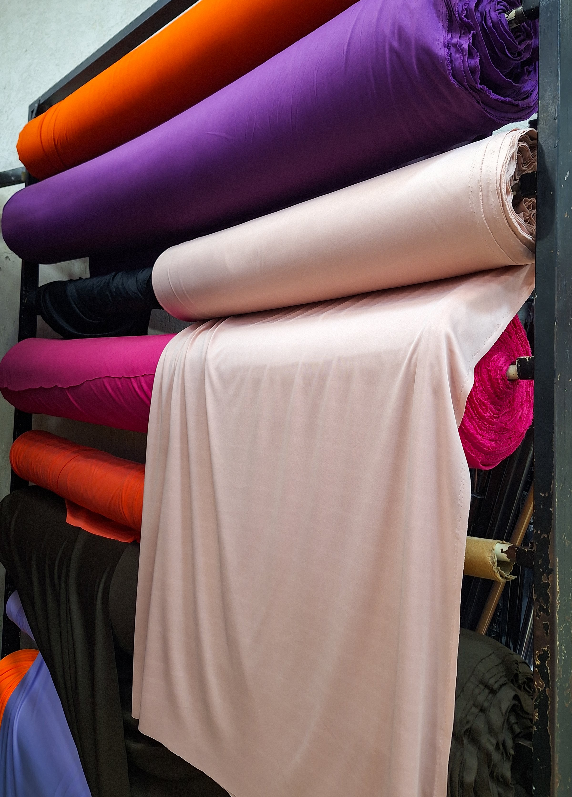 Fabrics stacked for sale in a store.