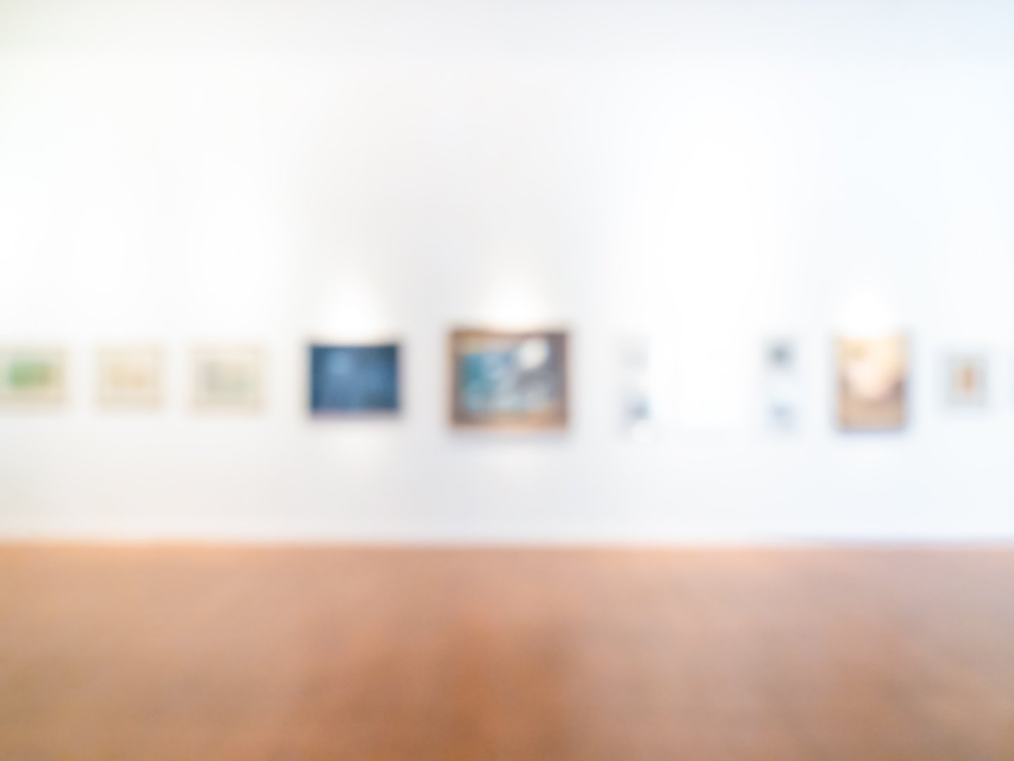 Blurred art gallery background with white walls and framed artworks. Concept of exhibition space, creative backdrop, modern museum, abstract design, and template for copy space or text overlay.