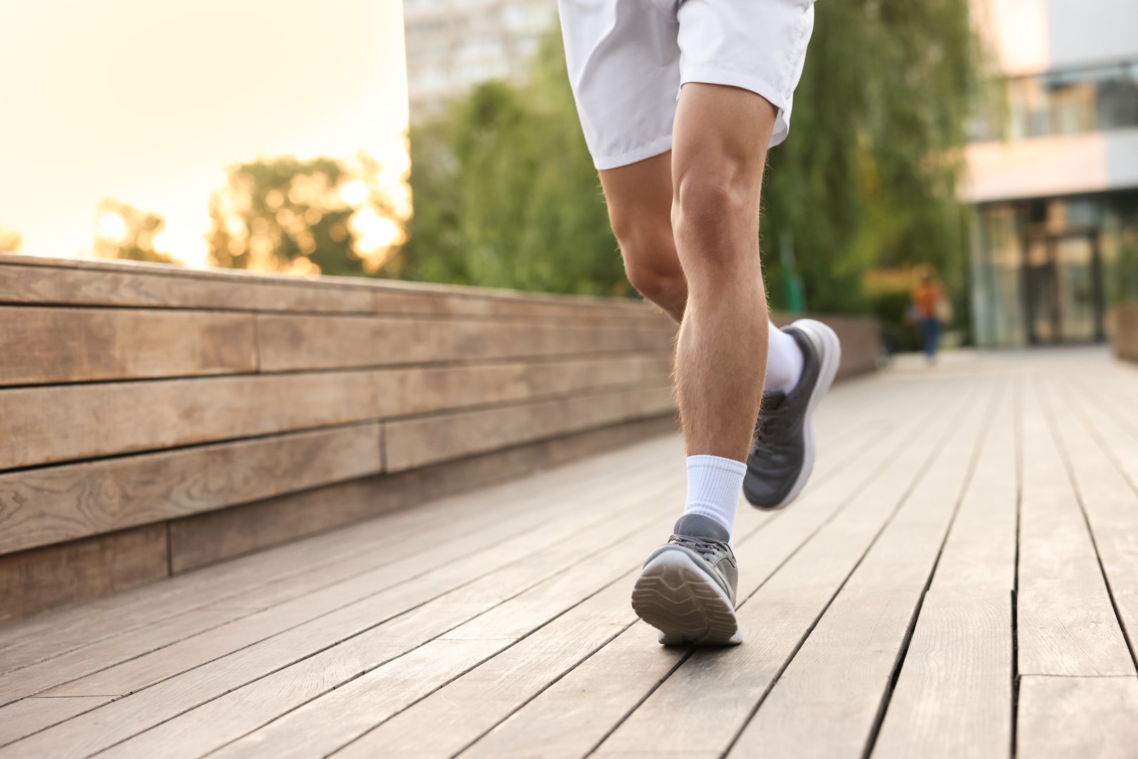 Athletic man in sneakers running outdoors, closeup