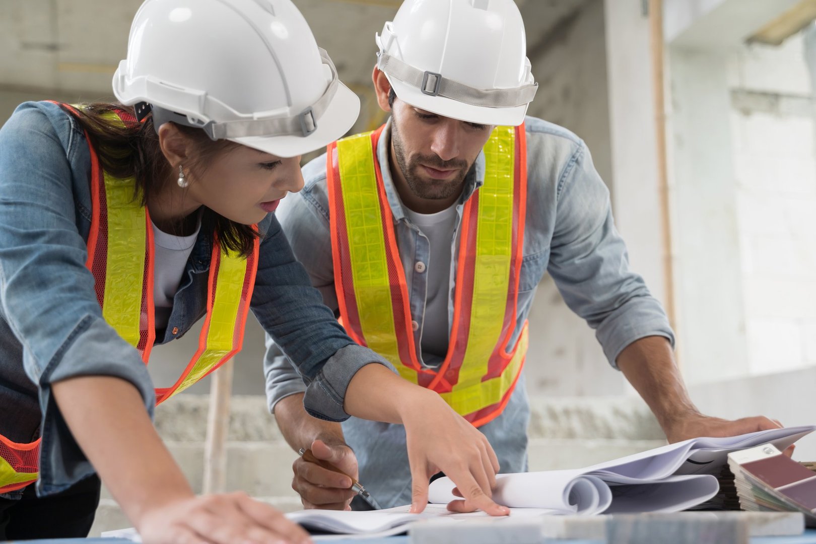 Working of engineer at building site talking and discussing on document . Teamwork site inspector and discuss together