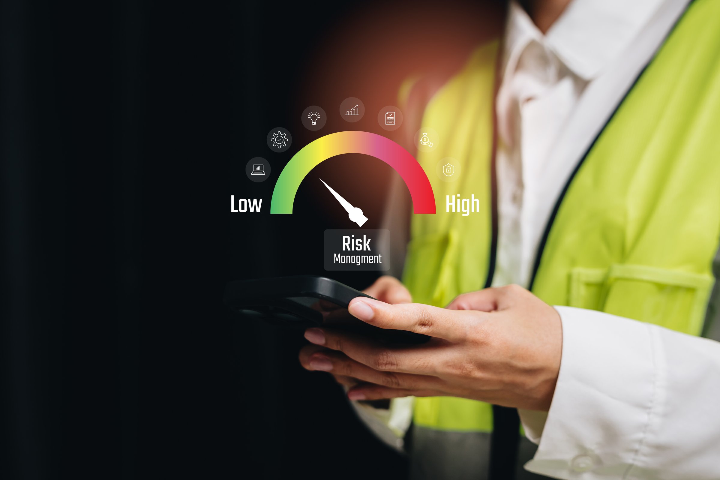 Risk concept. Illustration of Risk Management Indicator on Mobile Device Held by Worker in Safety Vest Representing Assessment Levels.