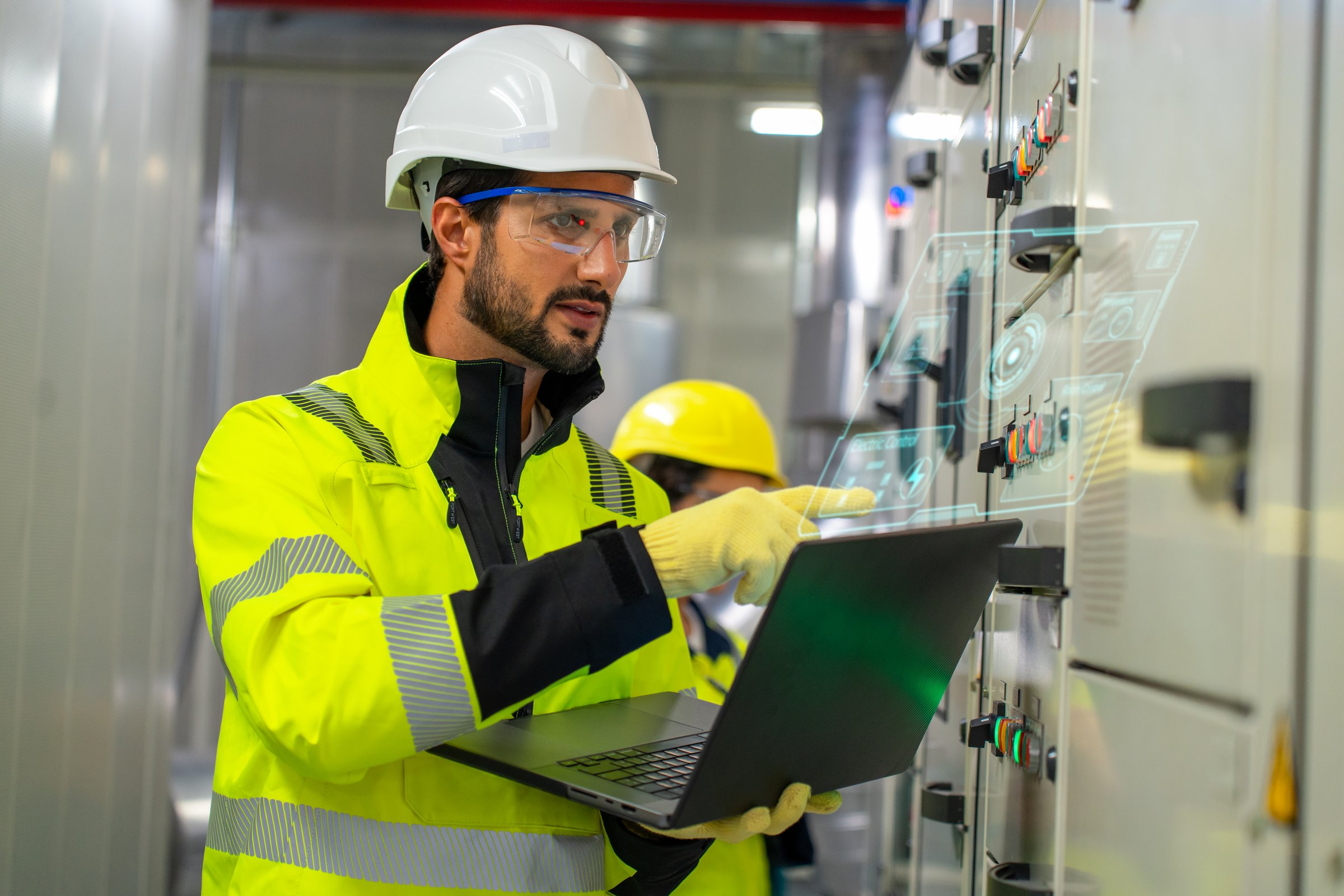 Supports industry by examining machinery, pipelines, and control systems with digital tools for optimal operation and safety.  Hispanic Latin Chiller engineer examine the HVAC control panel for check the working stage and electricity circuit at modern building.