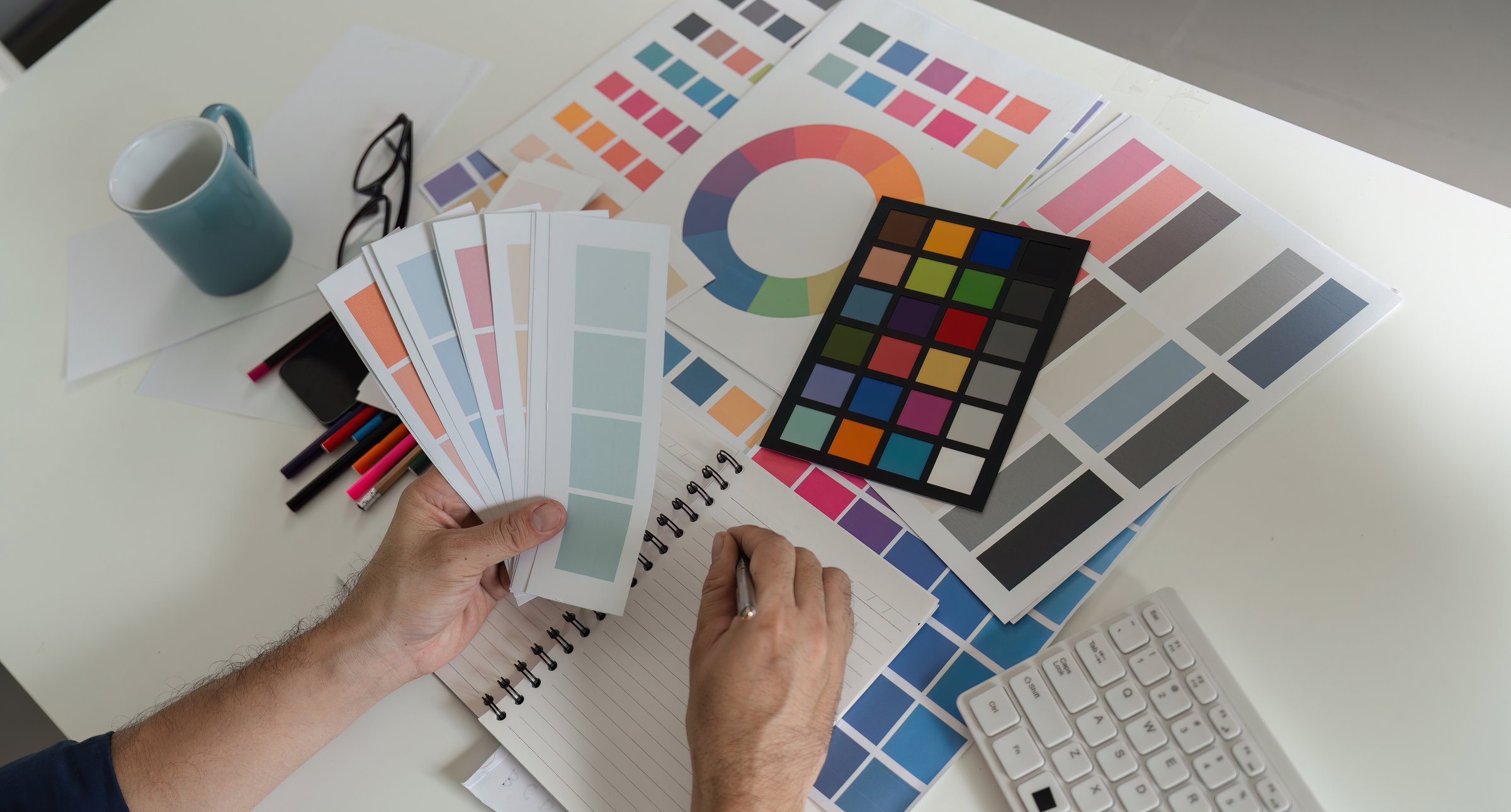 Graphic designer choosing vibrant color palettes for creative projects, showcasing design tools and color swatches.