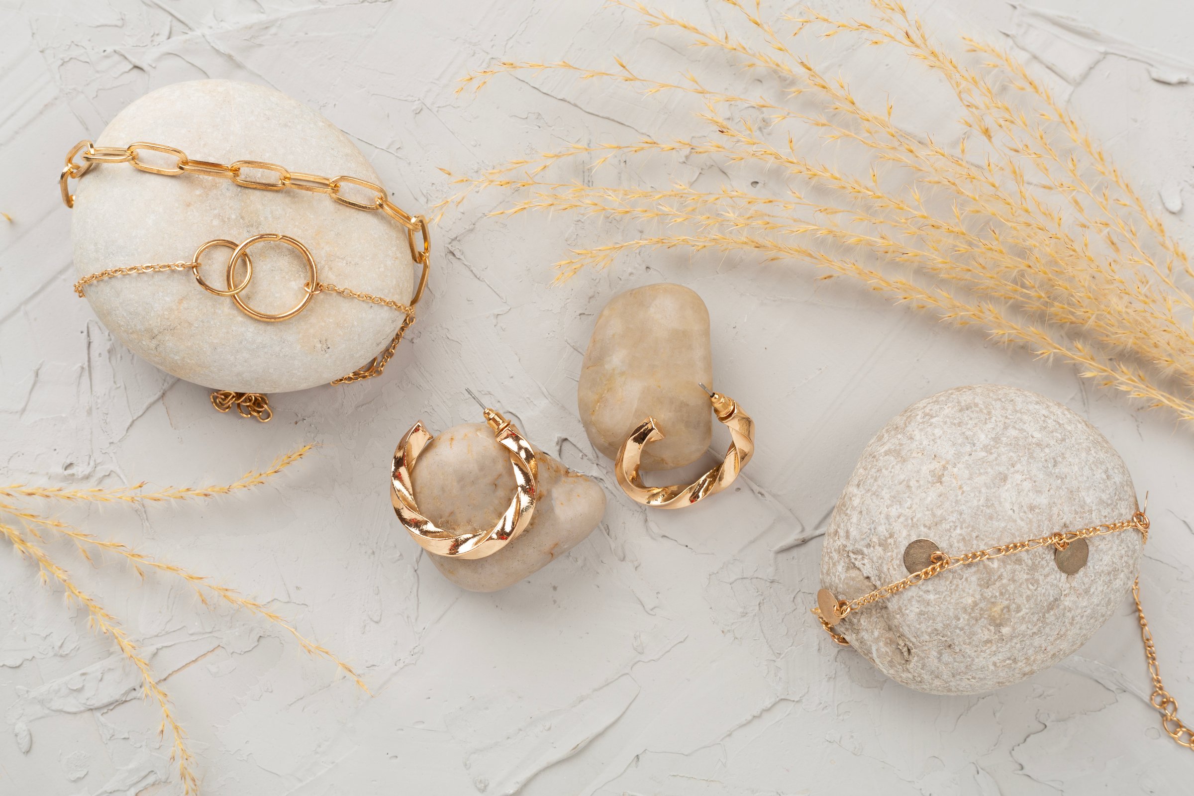 Elegant golden jewelry with decoration on concrete background, top view