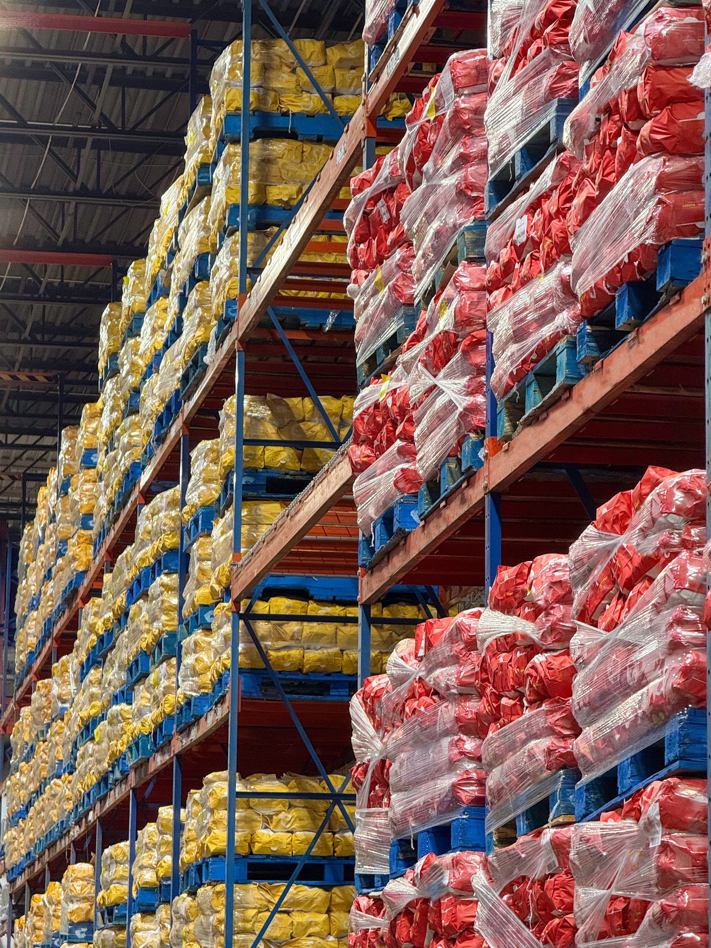 Pallets of 10 pound potato sacks stacked in distribution centre.