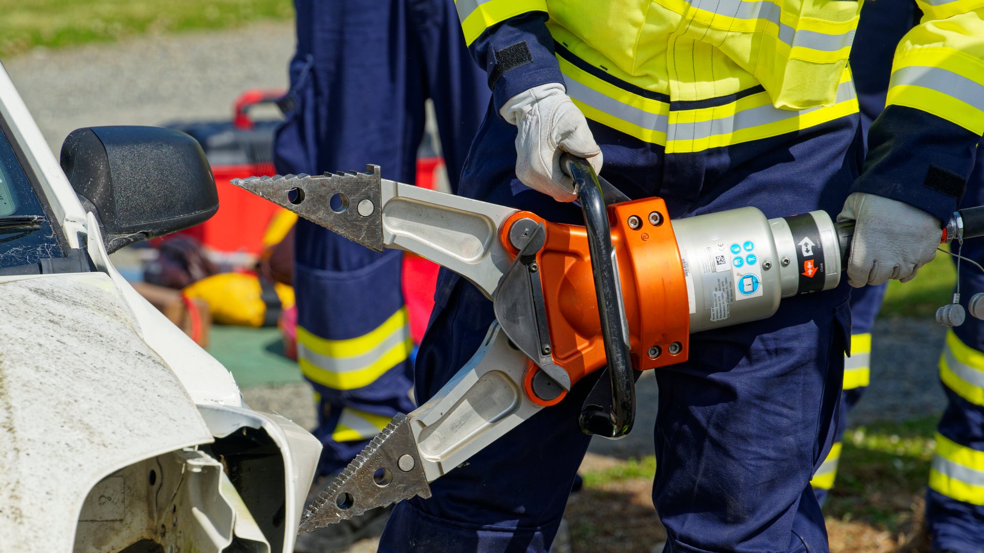 Motueka, Tasman District, Aotearoa / New Zealand - December 6, 2025: A firefighter about to pull open a wrecked car to release the occupants with a tool known as The Jaws Of Life.