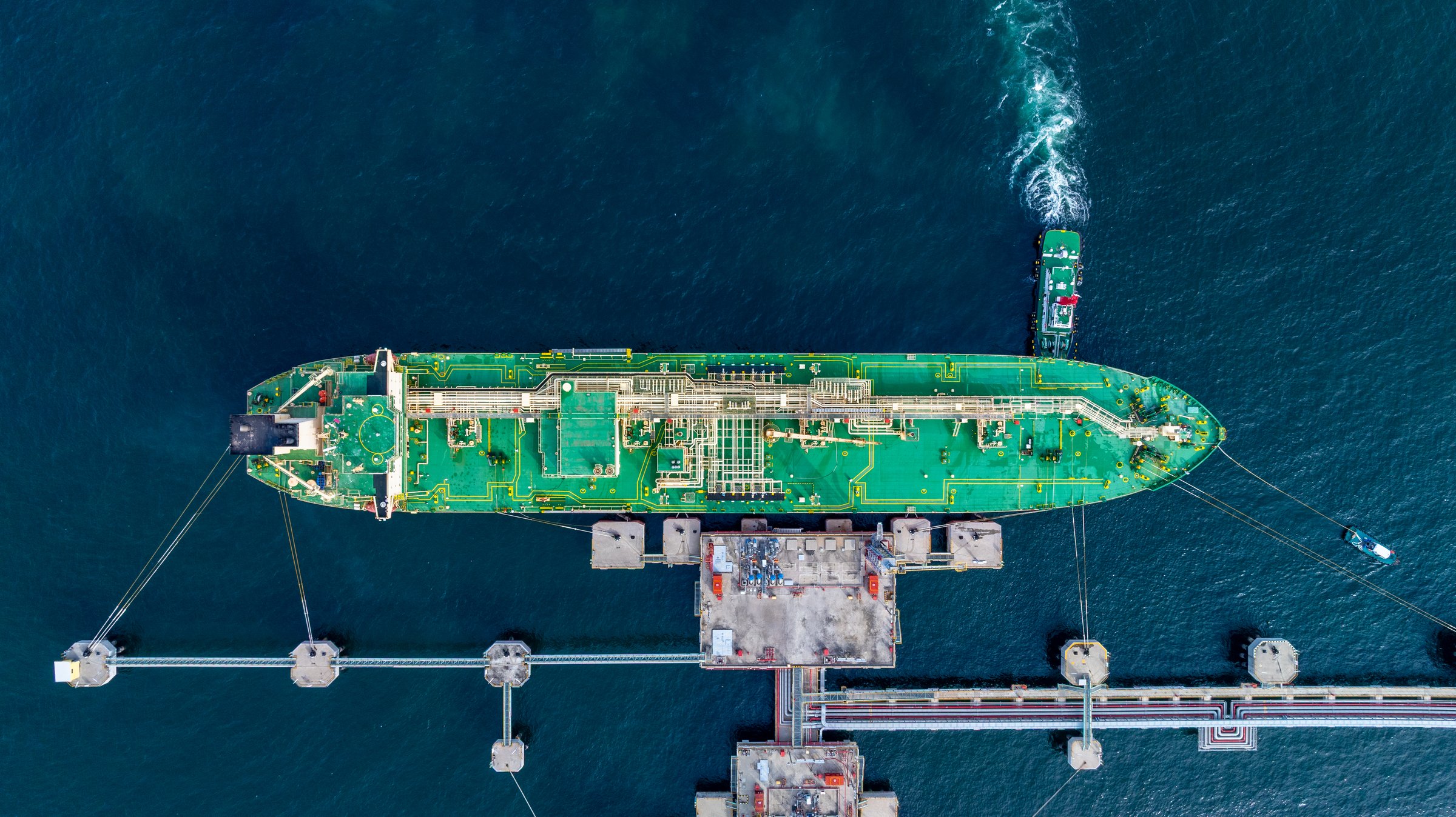Aerial view LPG tanker ship vessel loading and unloading in oil terminal refinery — global bitumen bulk shipping.