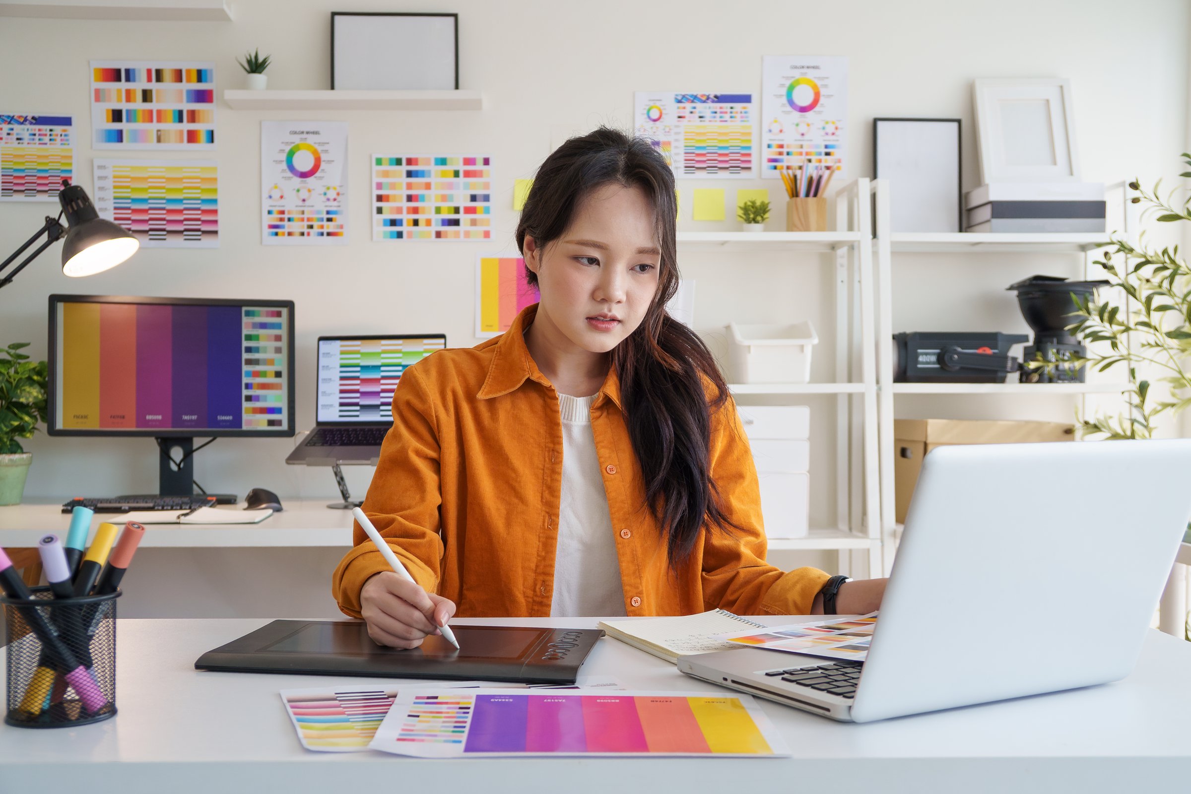 Creative young woman concentrating on design projects at her workspace.